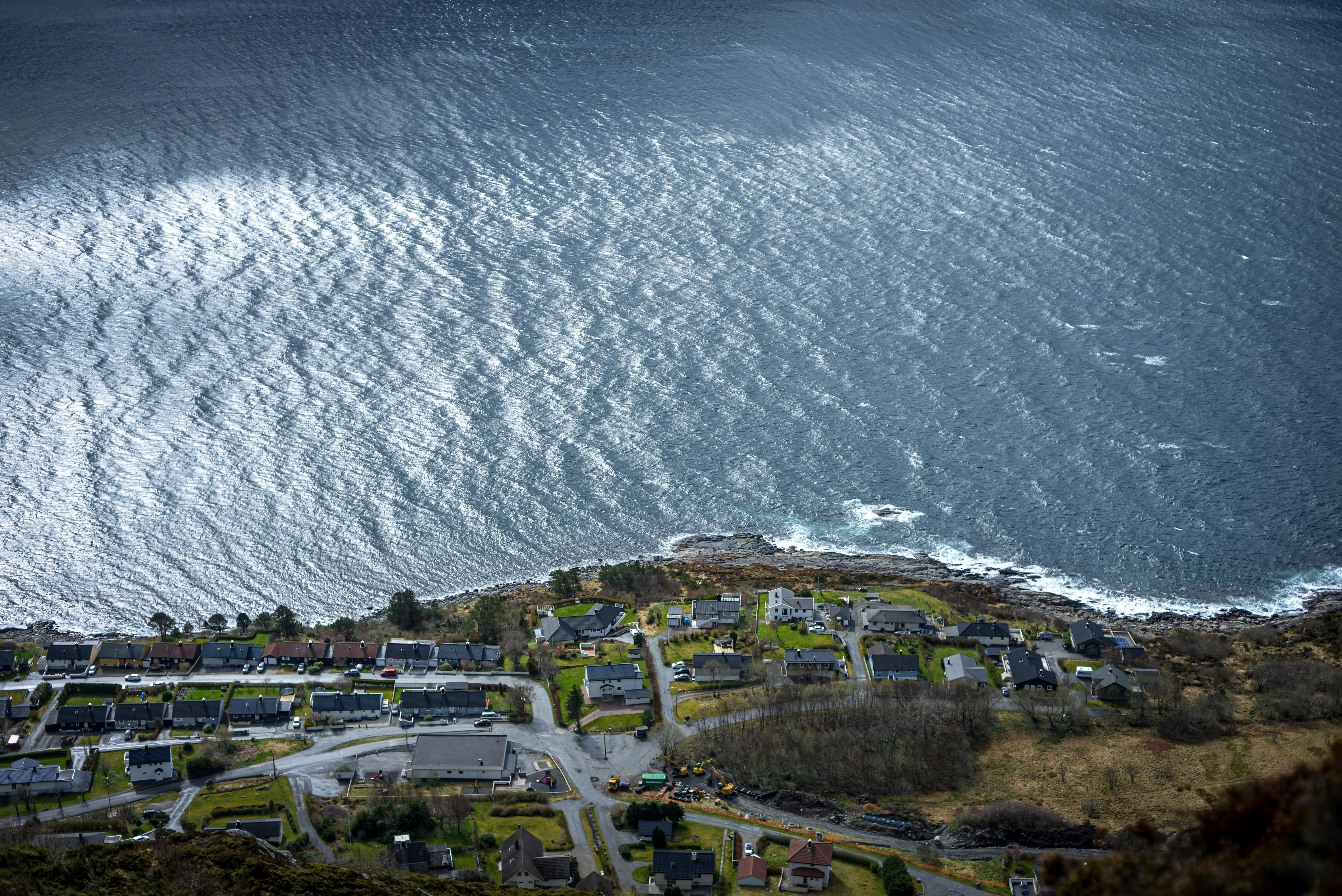 Small coastal village beside a choppy sea.