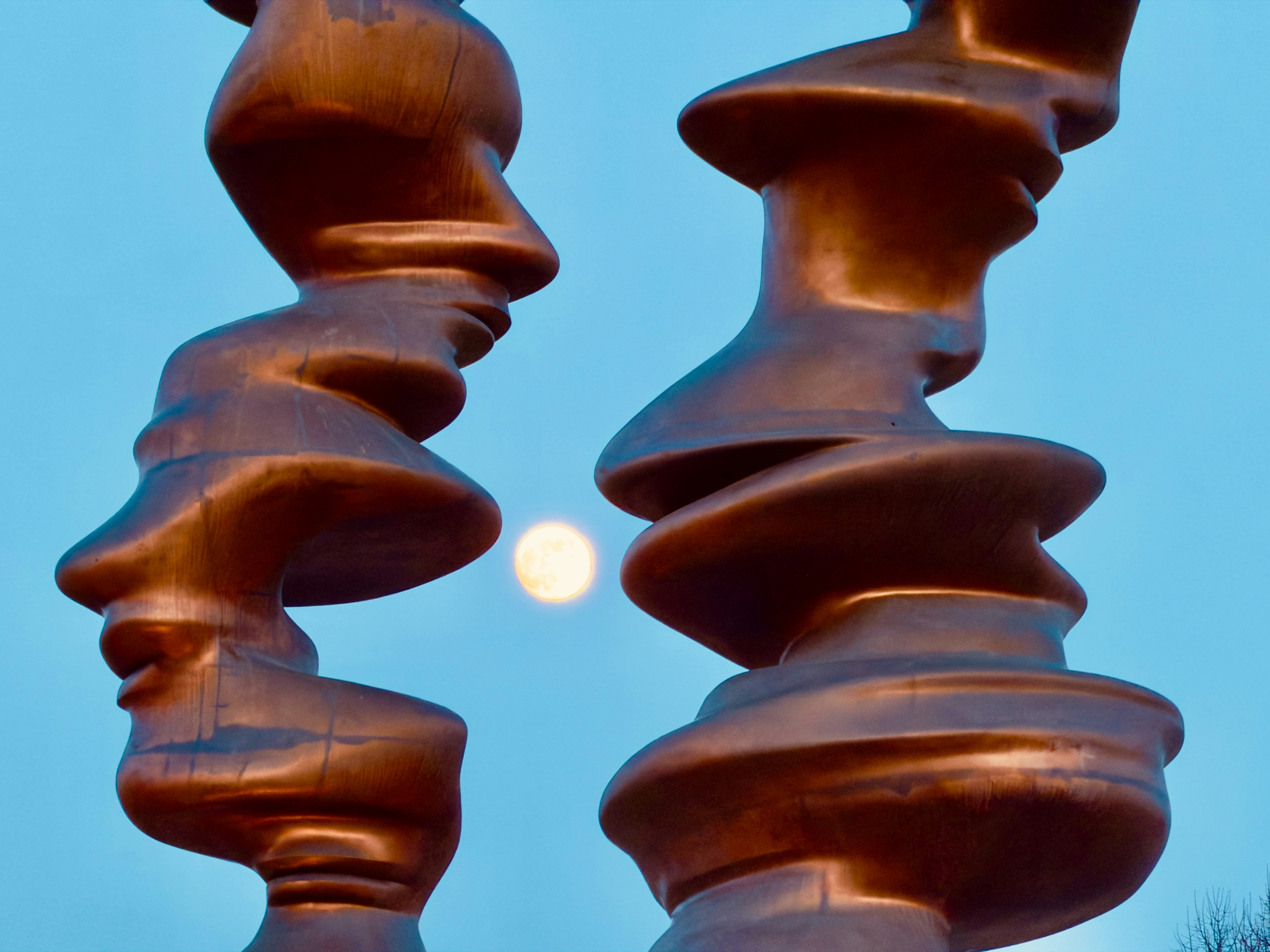 Two abstract sculptures with faces and moon
