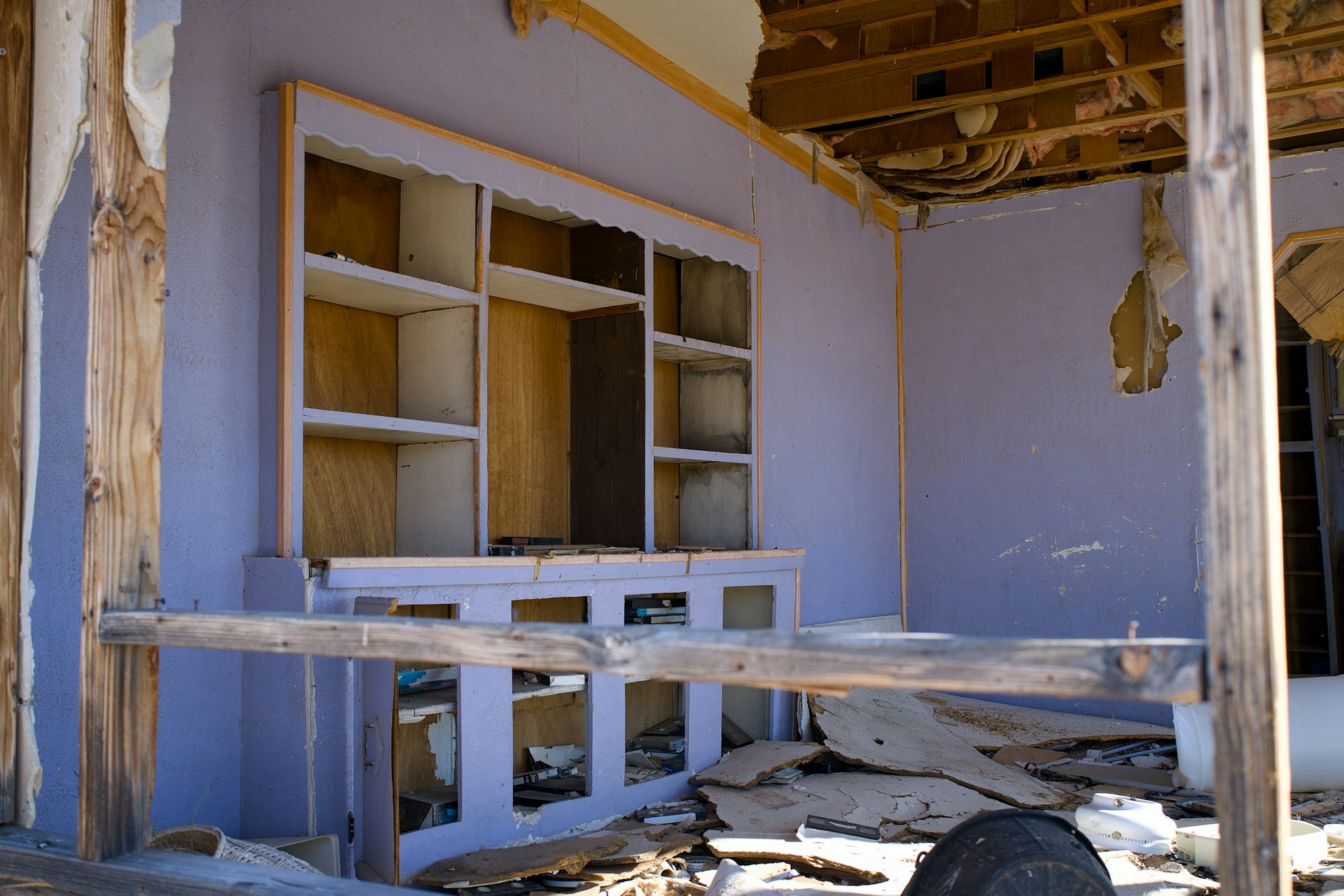 Dilapidated room with damaged shelves and debris