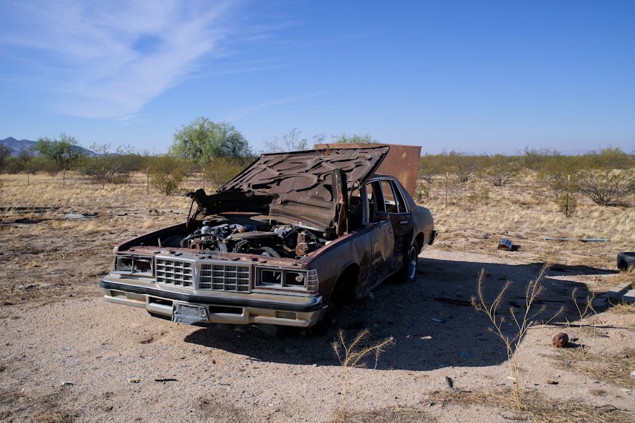 Rusted abandoned vehicle in a barren landscape