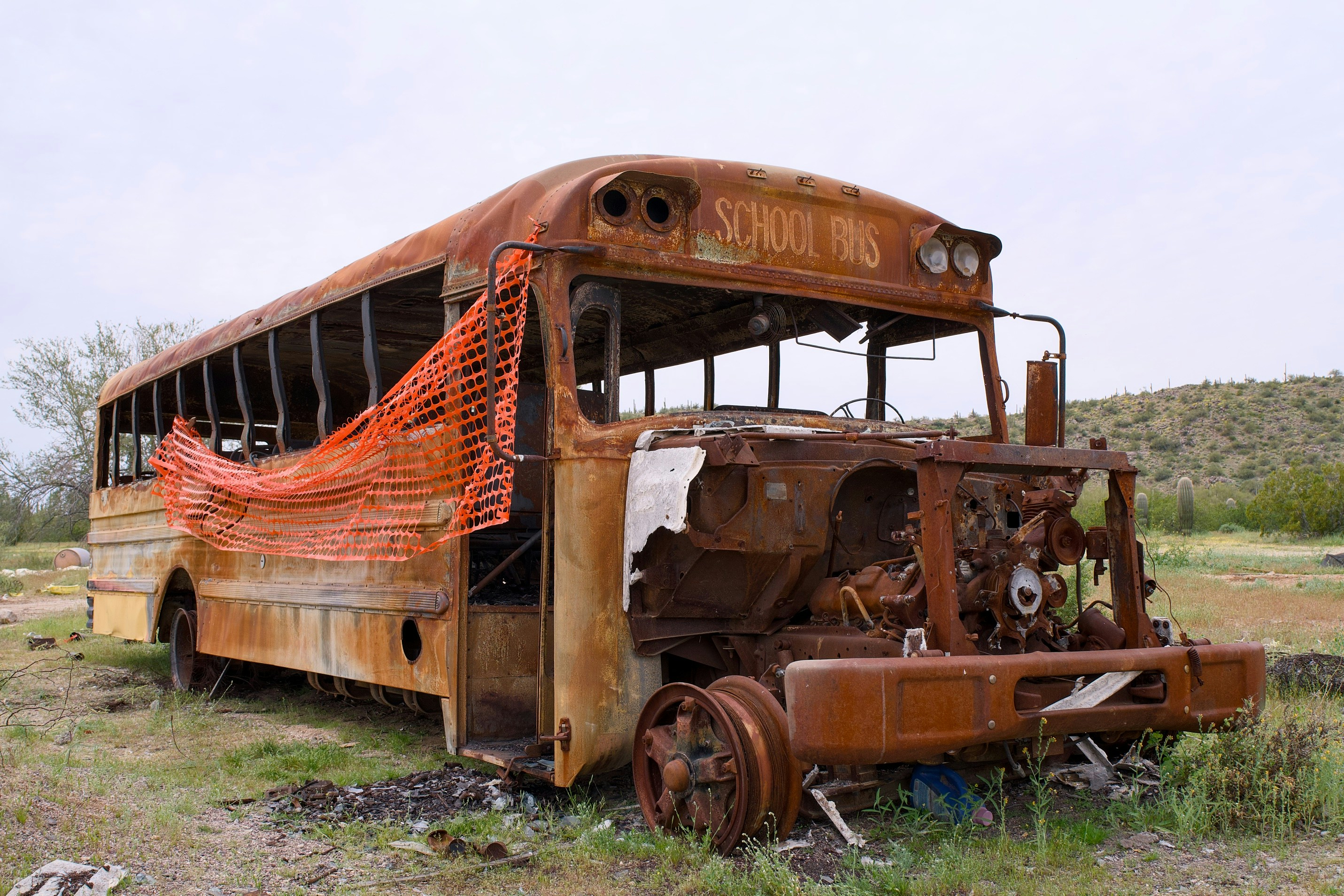 An old, rusted school bus abandoned in a field.