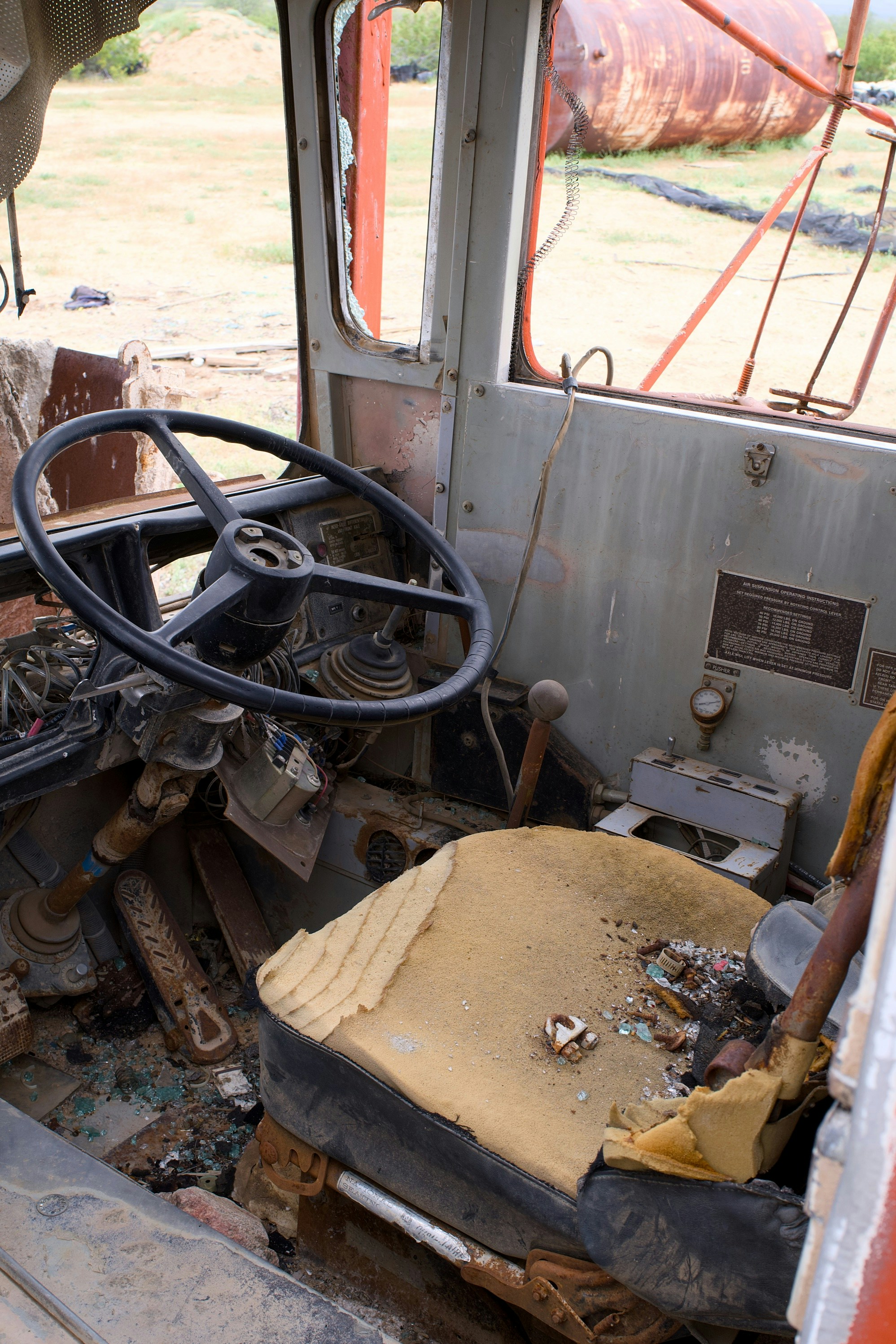 Interior of a damaged, abandoned vehicle with torn seats.
