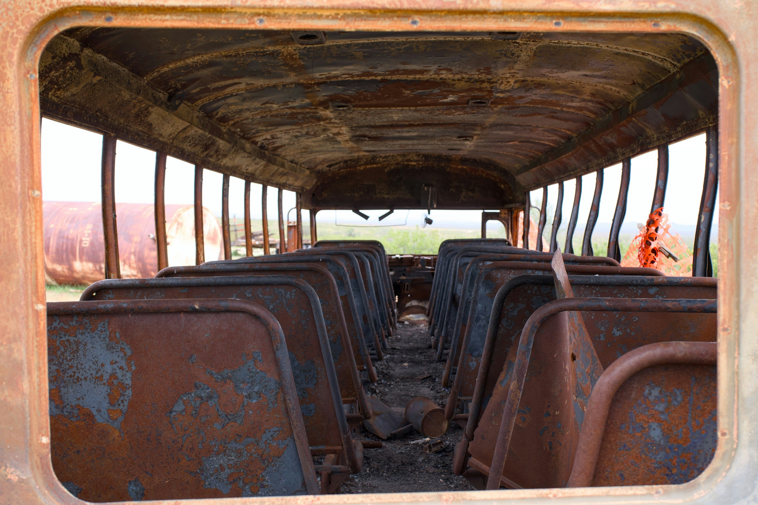 Interior of a burnt-out school bus with empty seats.