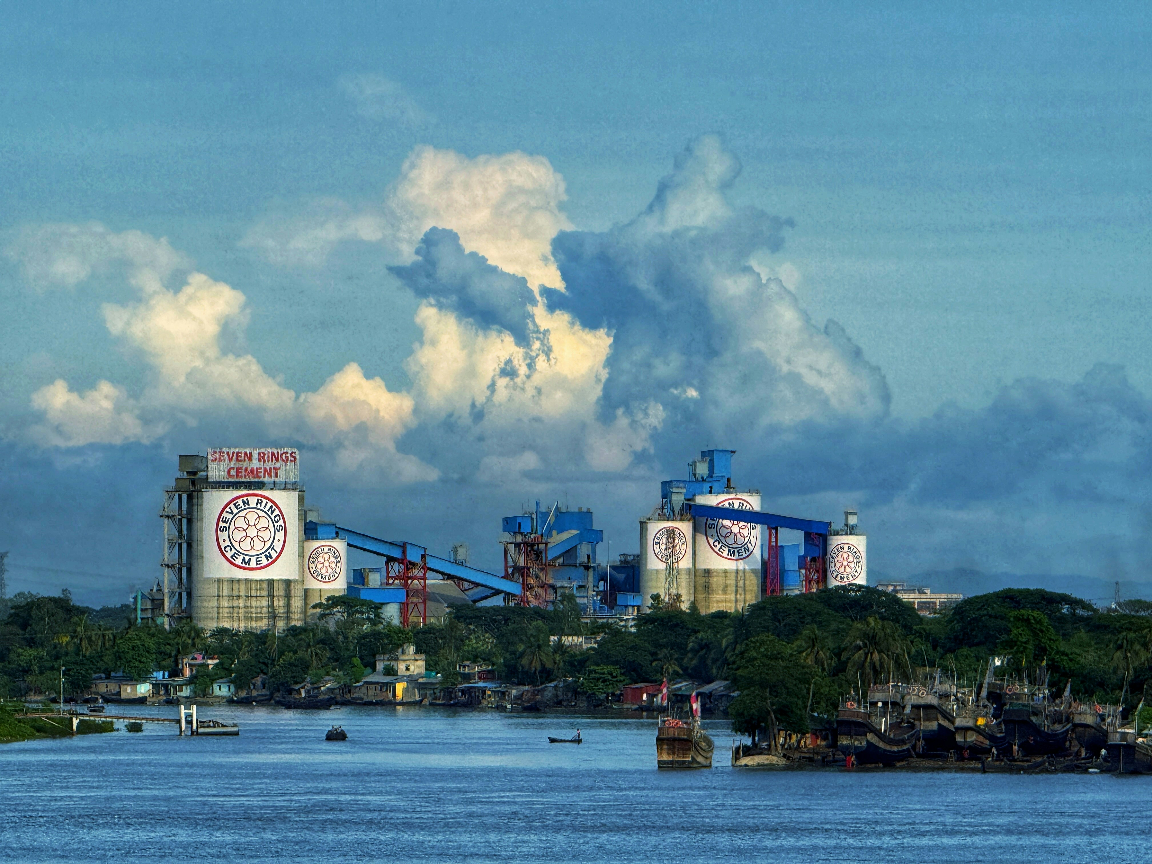 Industrial complex by the river under a cloudy sky