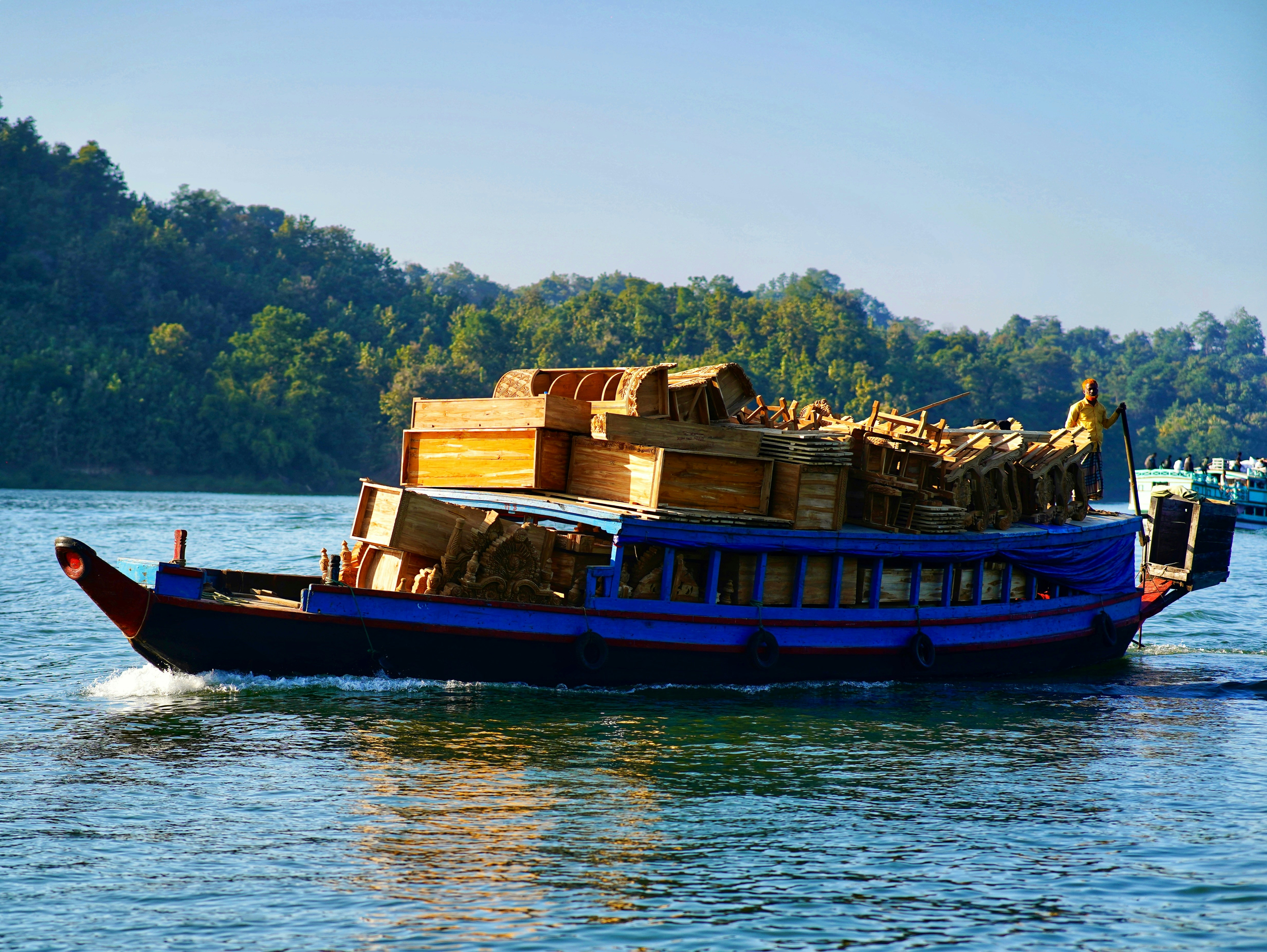 A blue boat carrying cargo on the water