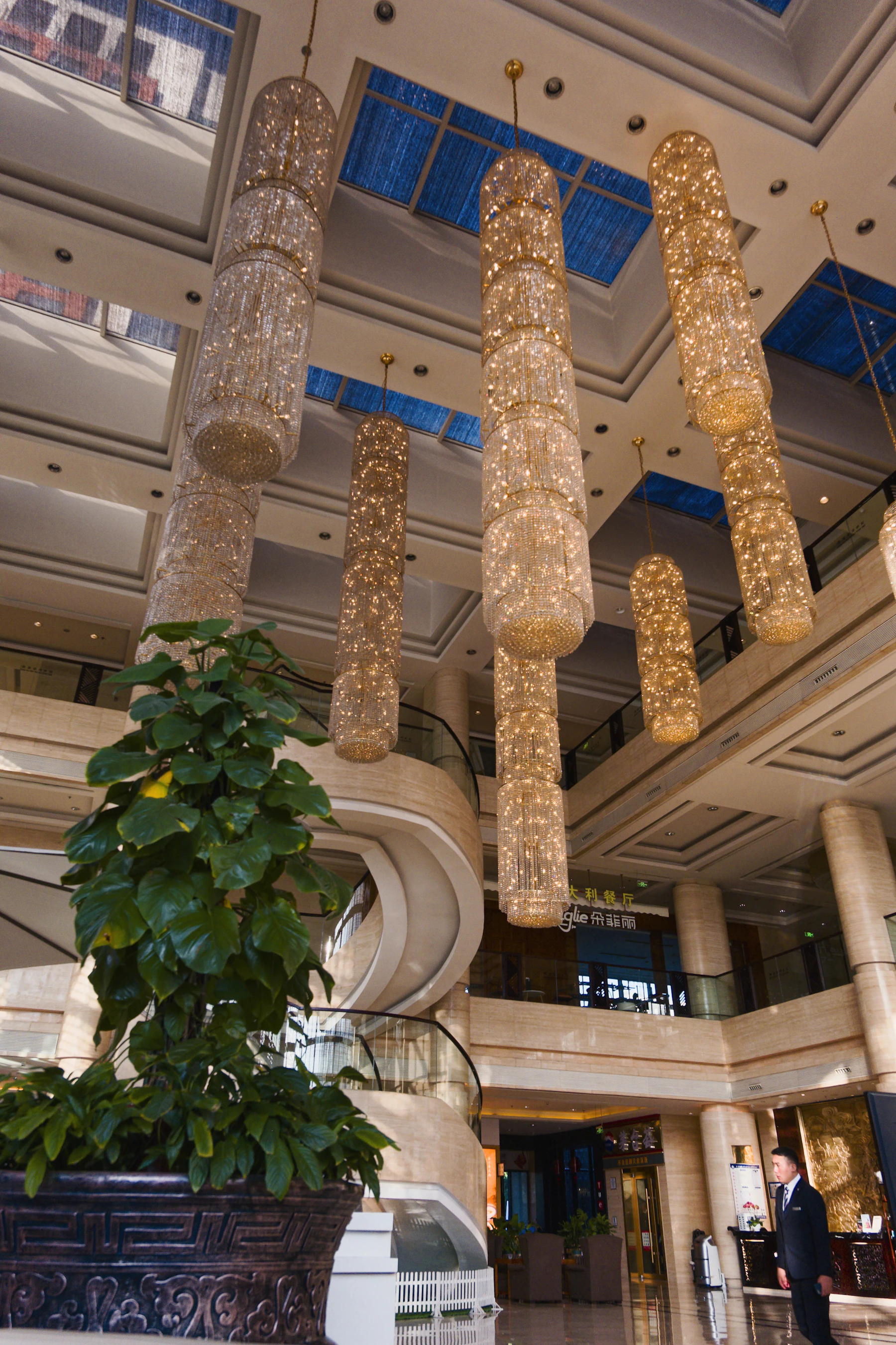 The hall of a great hotel beneath its chandeliers