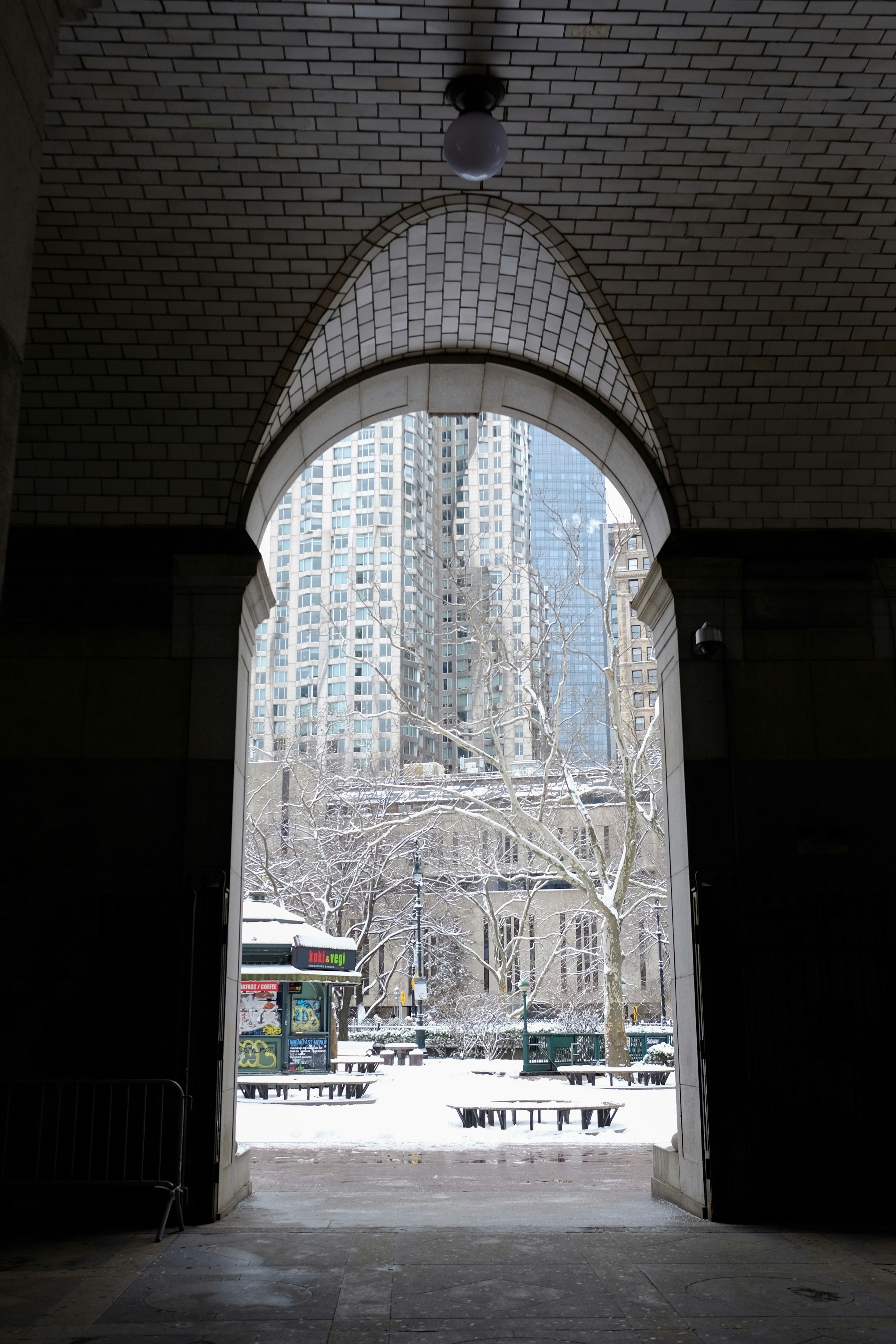 Snowy park view through an arched entryway