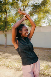 Young woman with arms raised outdoors