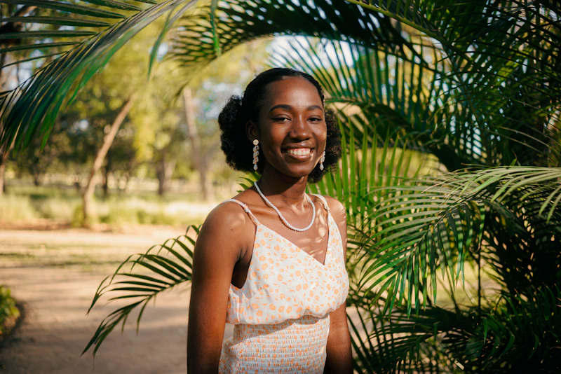 Smiling woman in a dress, surrounded by nature
