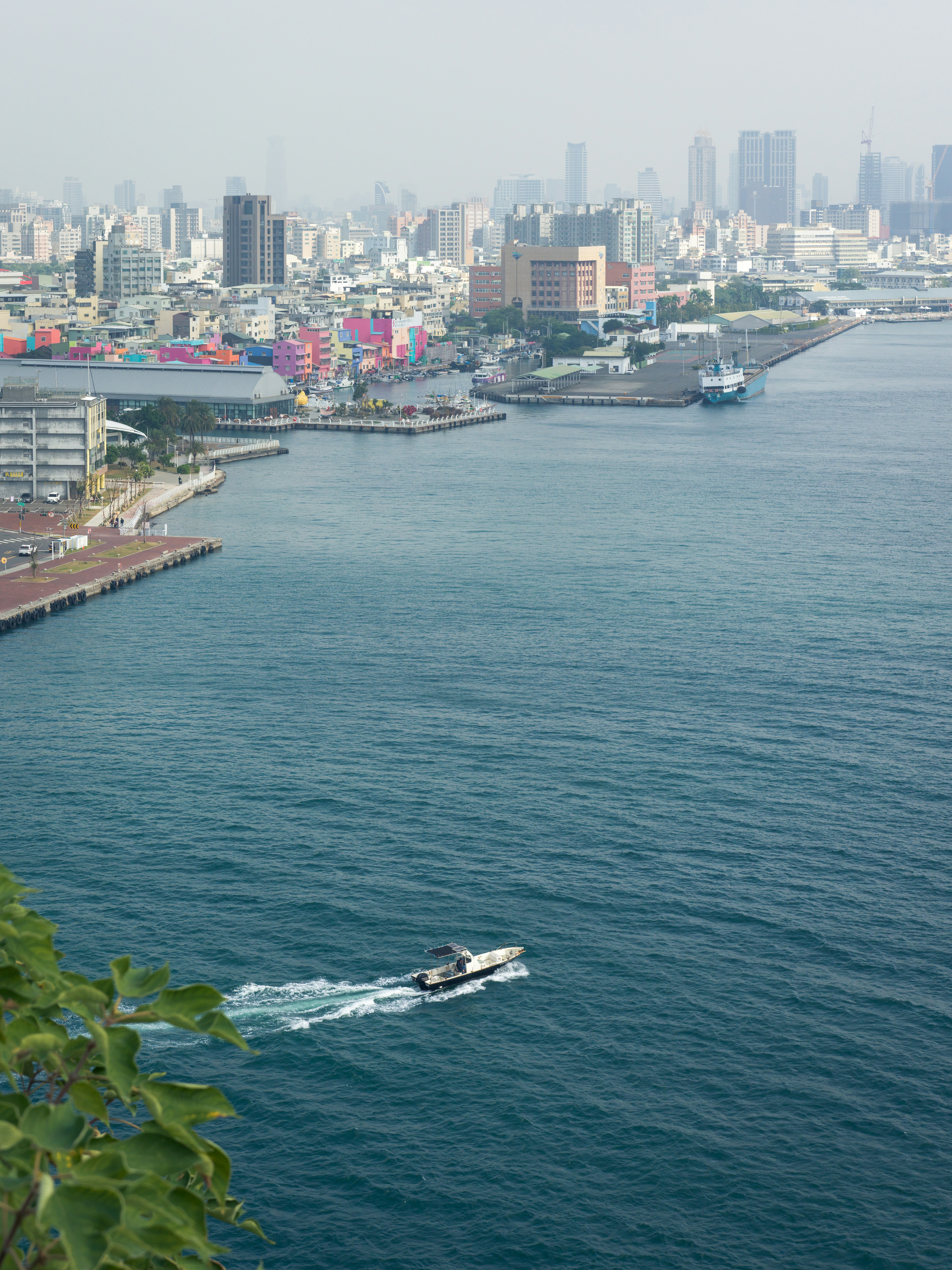 Boat sailing on blue water near city harbor
