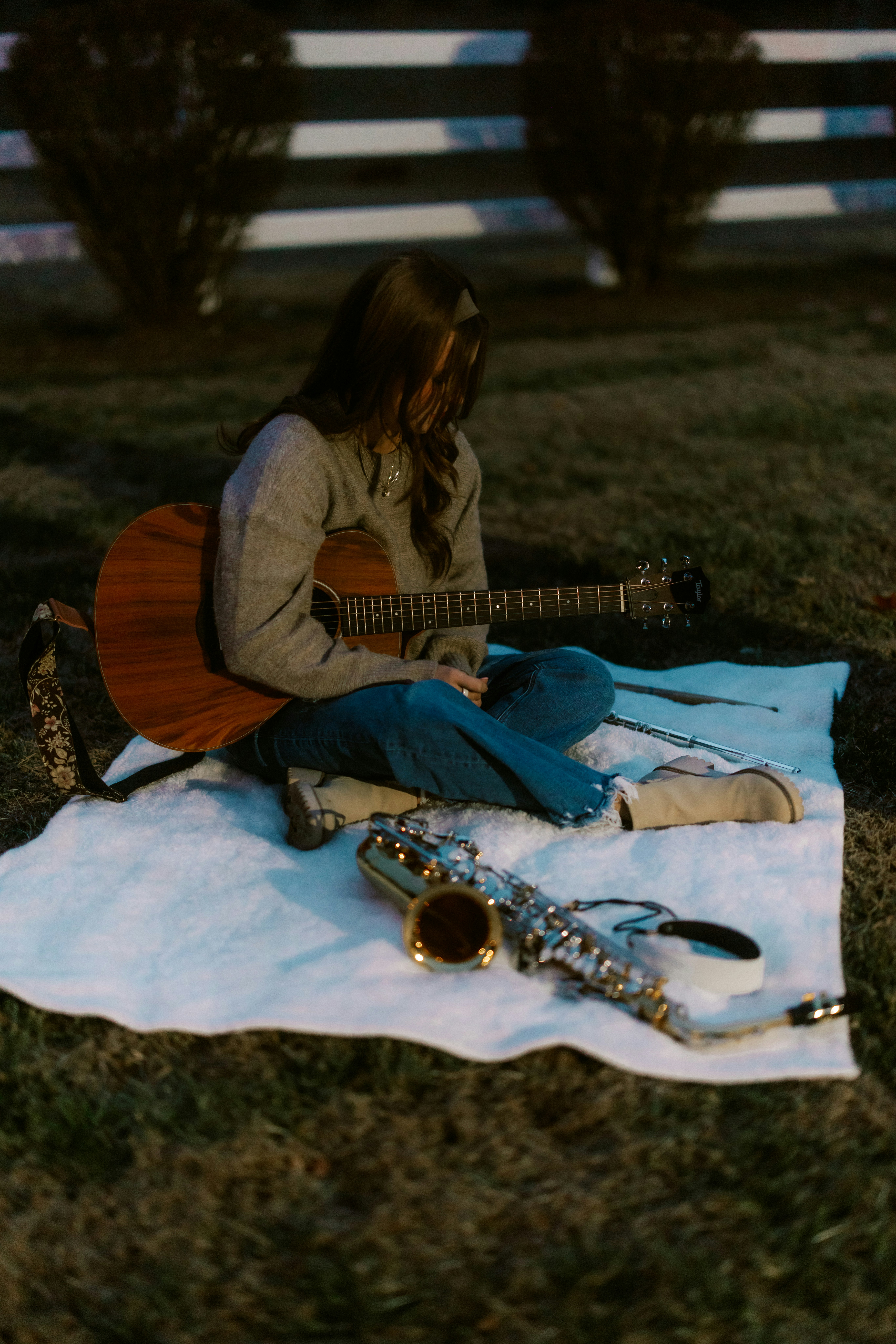 Woman with guitar and saxophone on blanket
