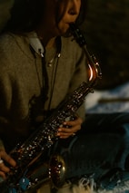 Woman playing a saxophone outdoors at night