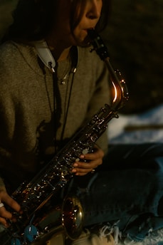 Woman playing a saxophone outdoors at night