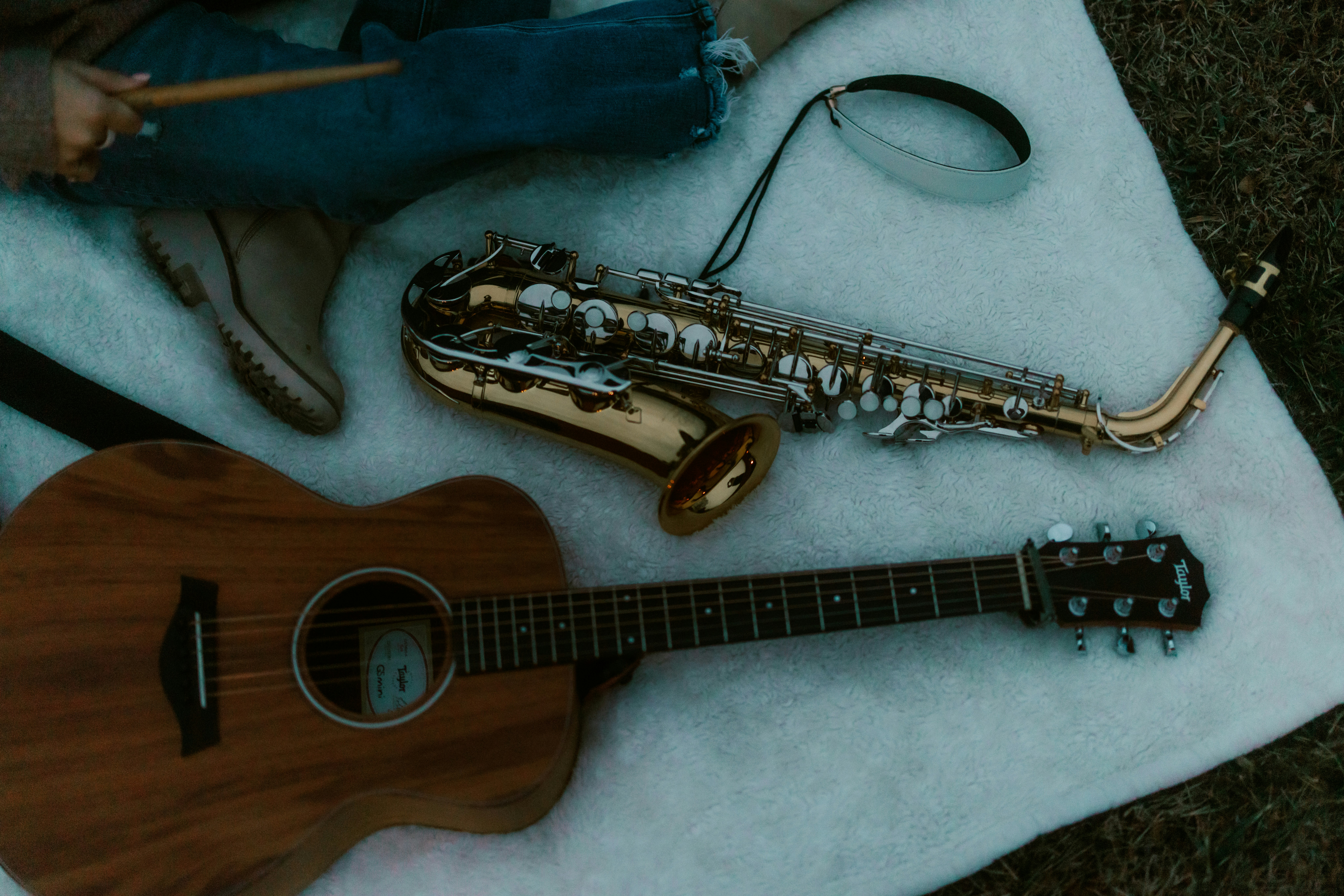 Acoustic guitar and saxophone on a blanket