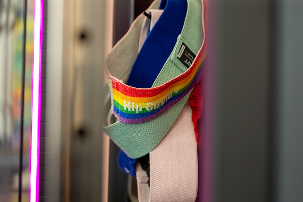 Striped fabric resistance loop band hanging from a hook on a gym wall