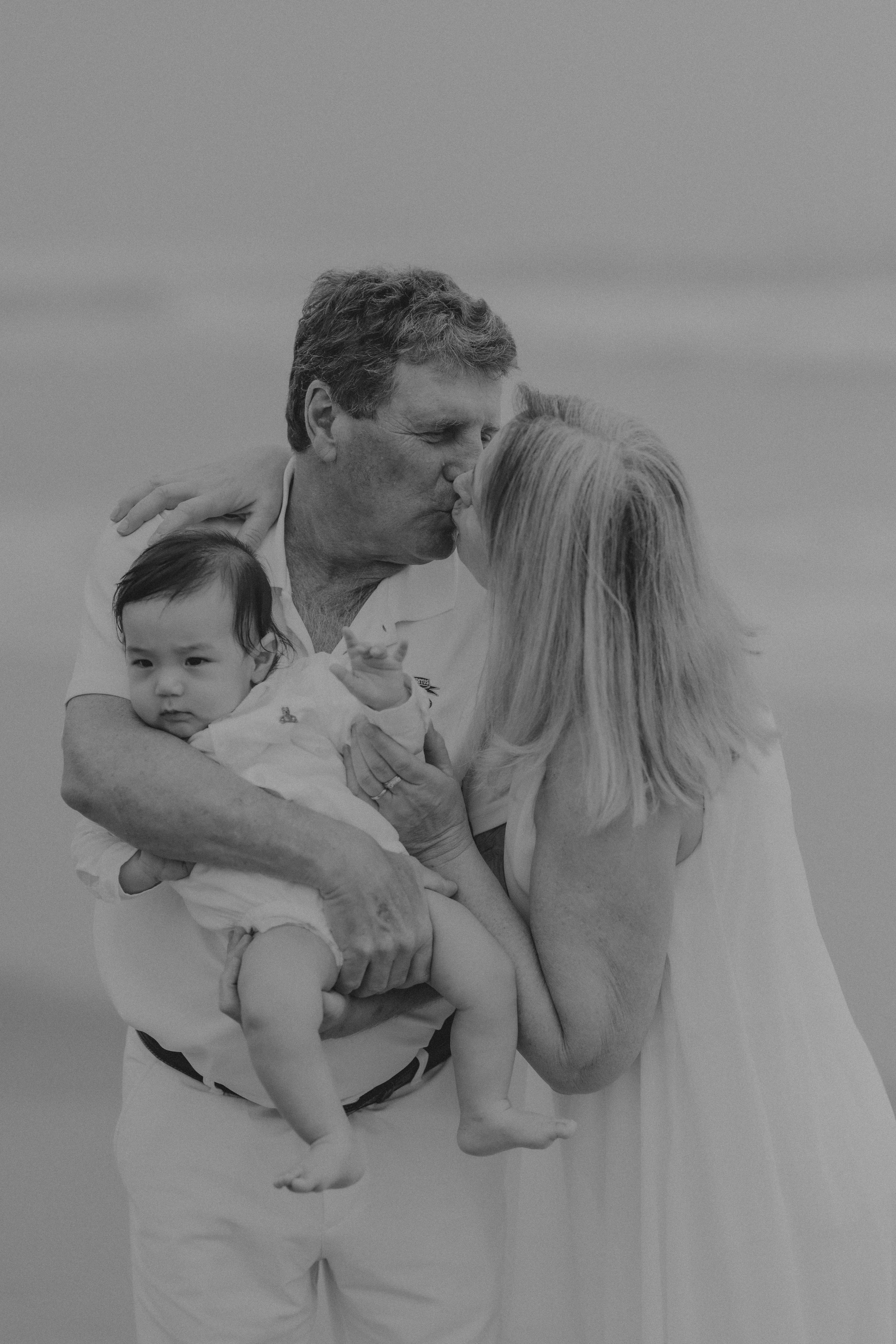 Nonni che si baciano con il bambino sulla spiaggia