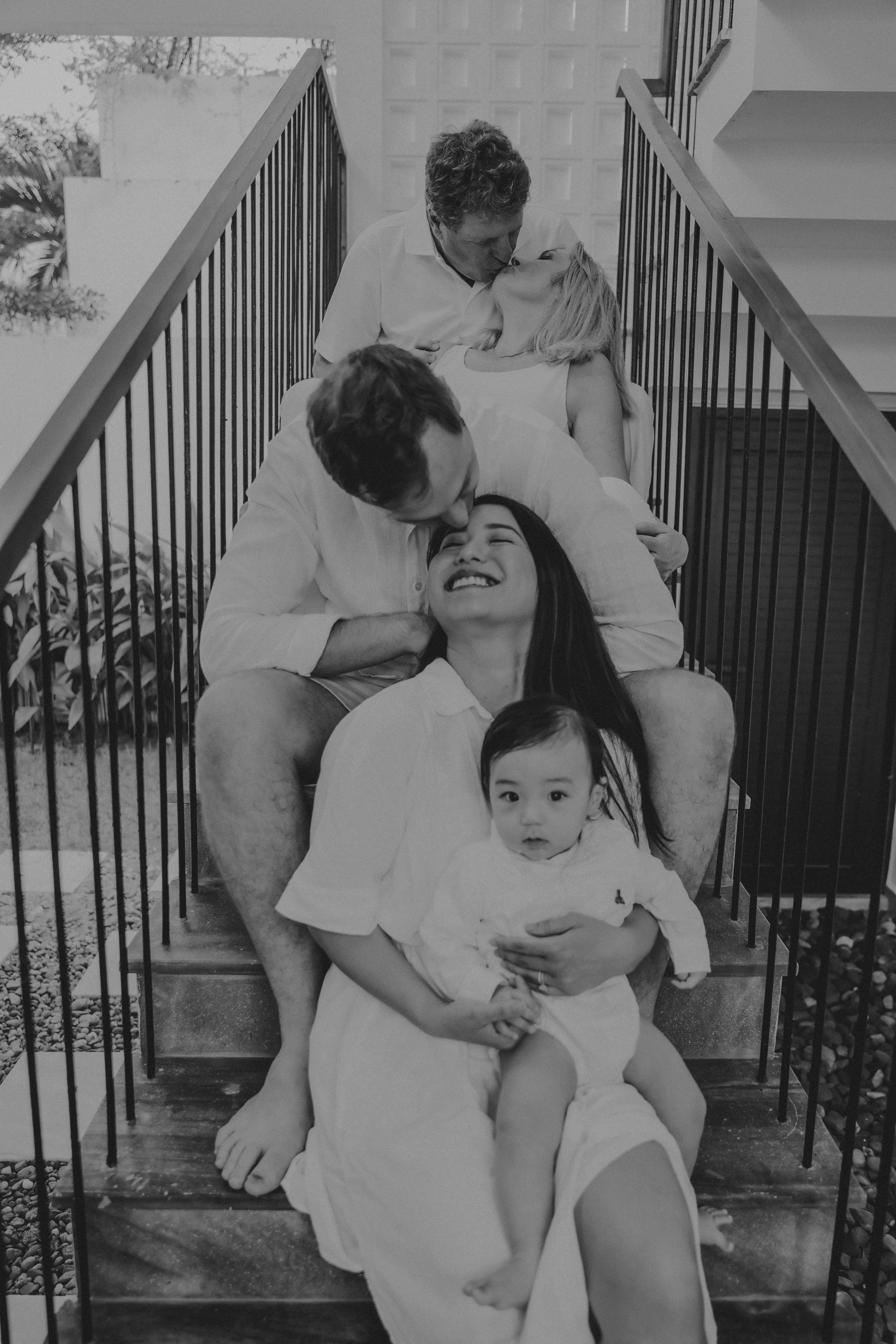 Famille assise dans les escaliers, s’embrassant affectueusement