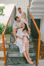 Family in white outfits sitting on stairs