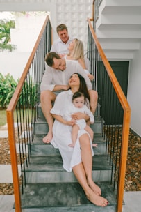 Family in white outfits sitting on stairs
