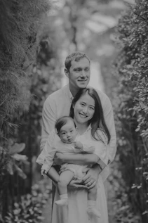 A family with a baby posing outdoors