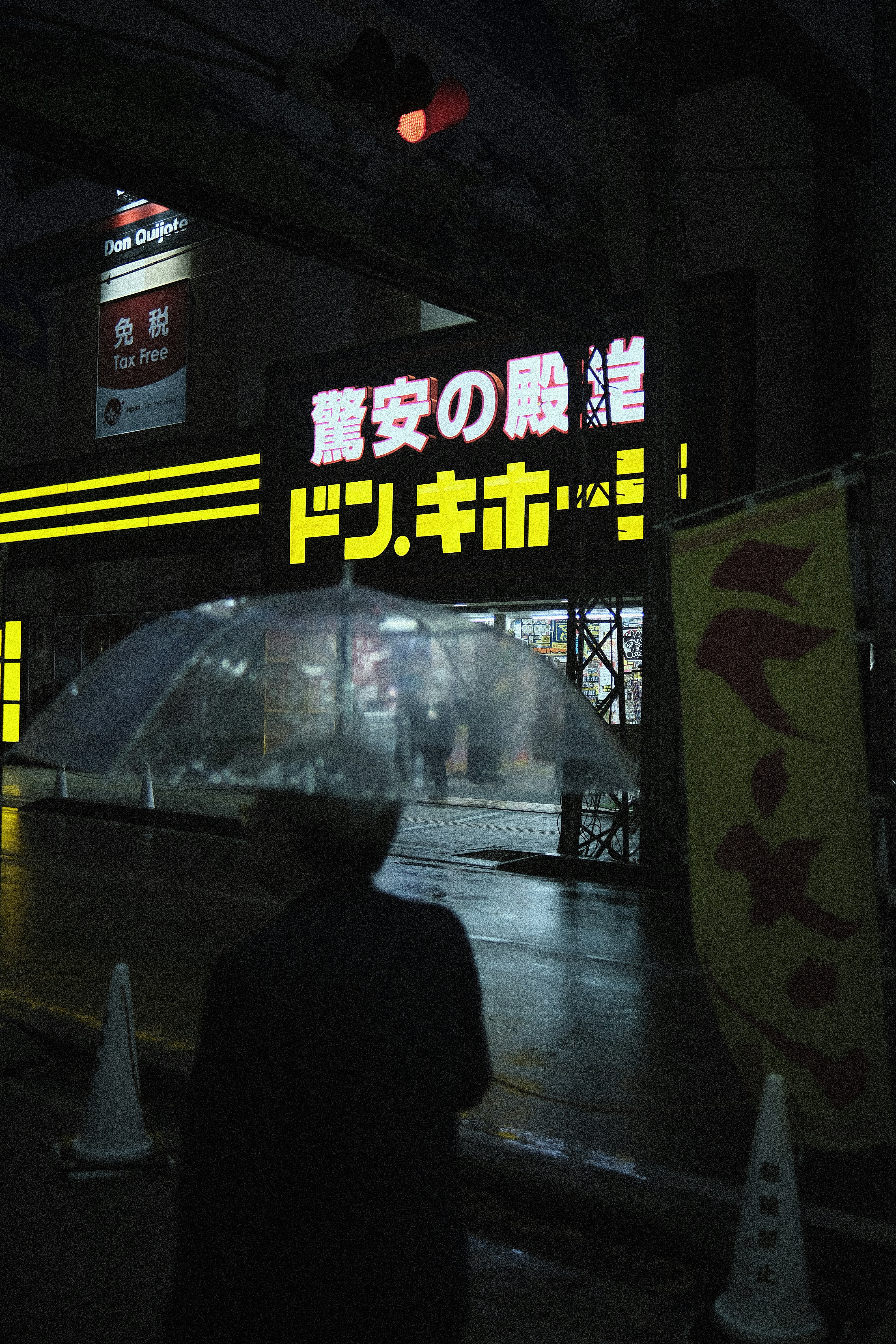 Person with umbrella on a rainy city street at night.