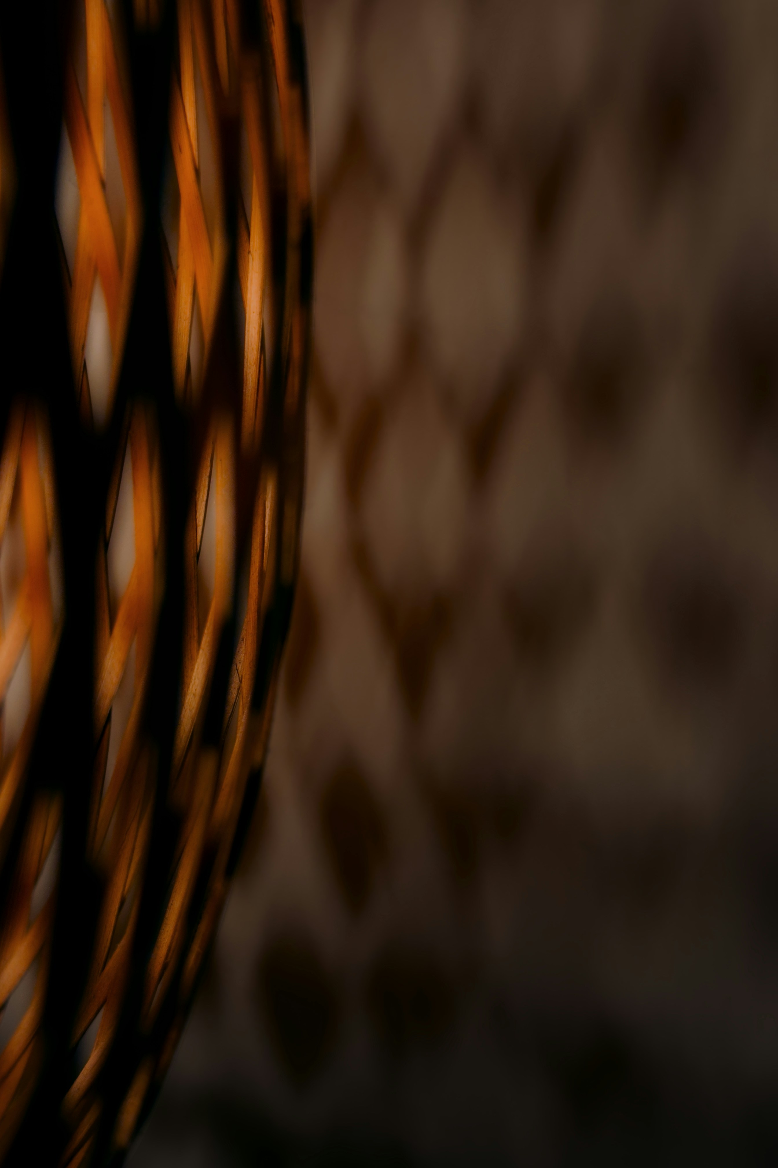 Woven lantern casting diamond shadows on wall