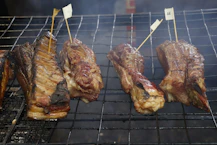 Several pieces of smoked meat on a grill