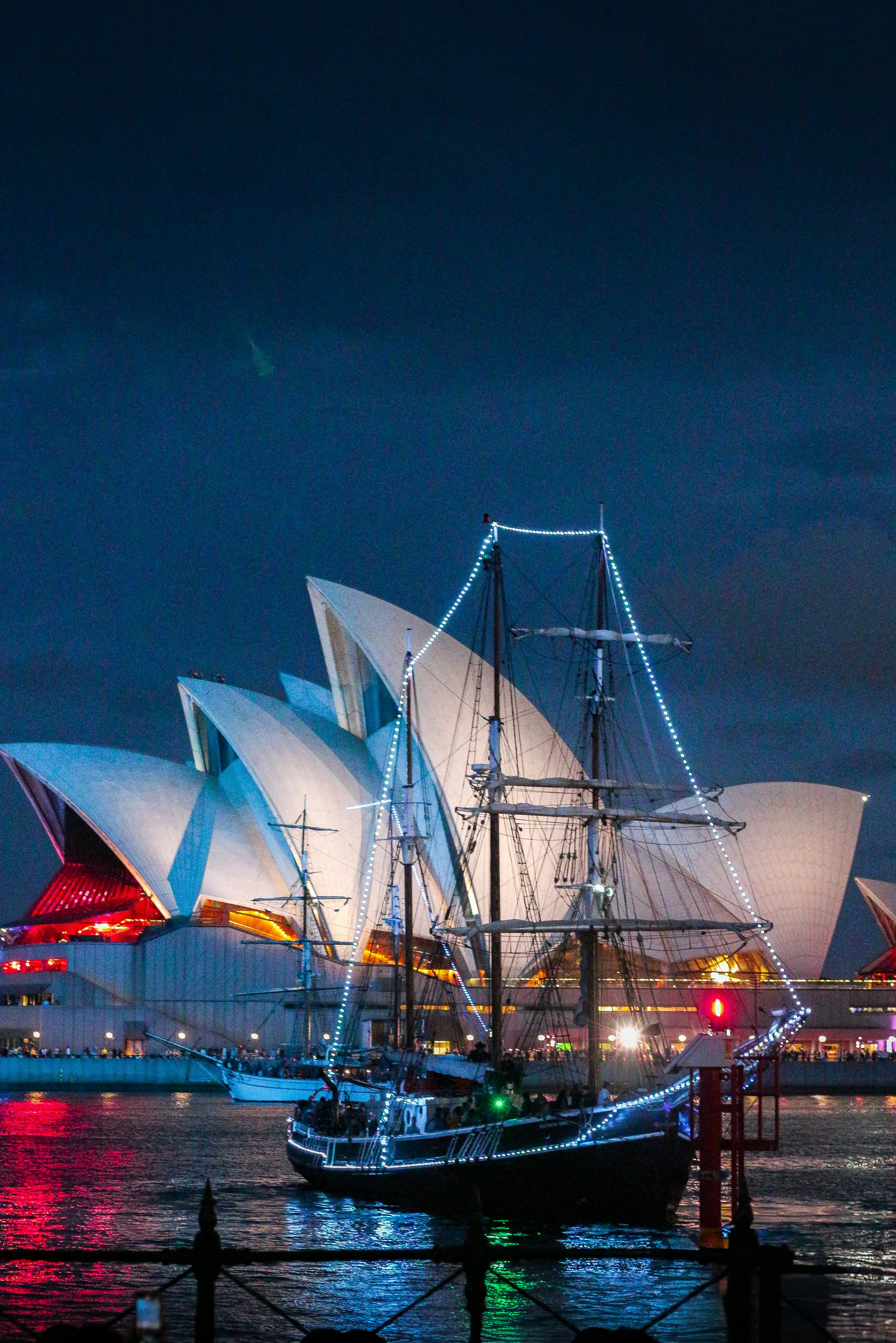 Tall ship illuminated with lights near sydney opera house