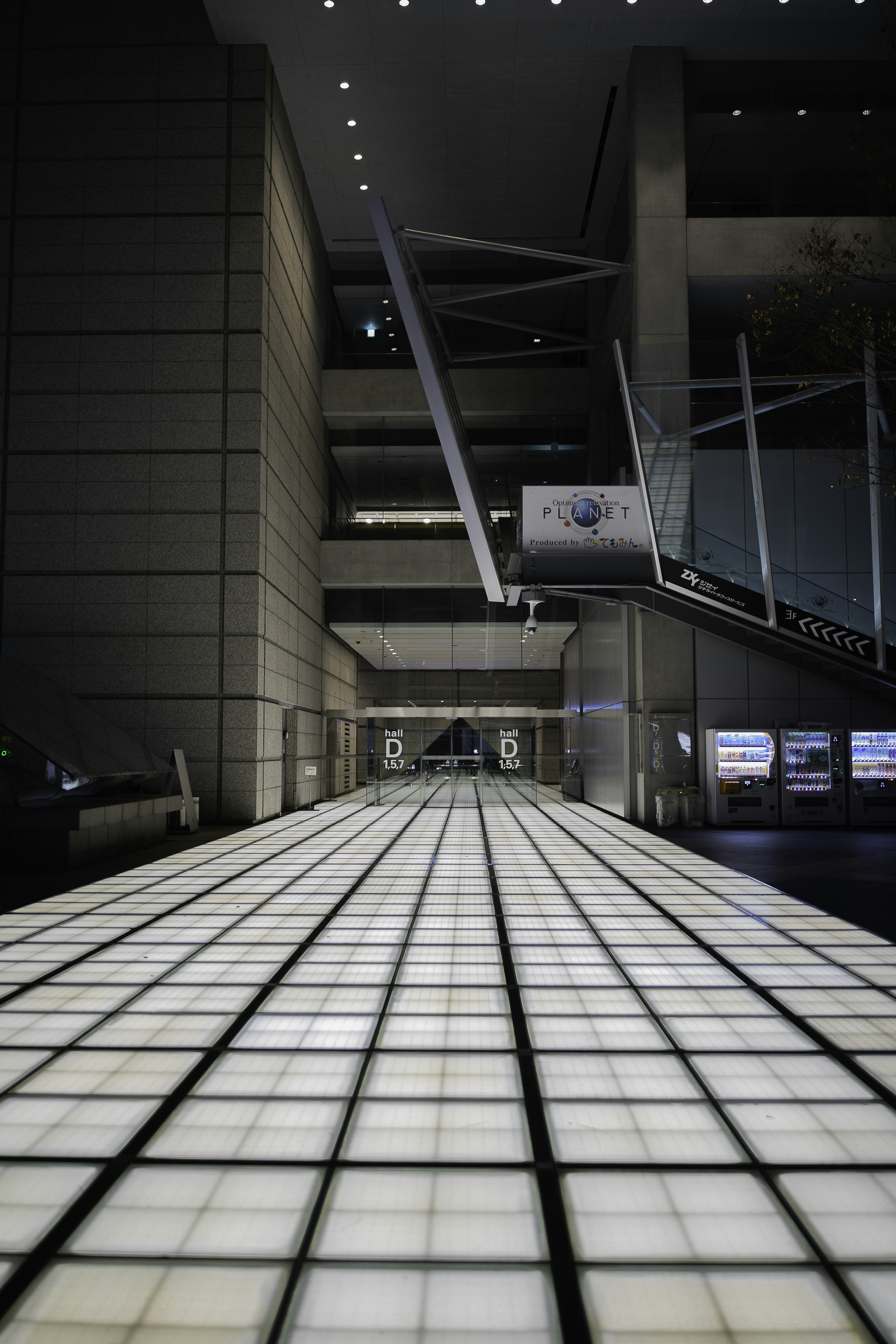 Modern hallway with illuminated floor and escalators