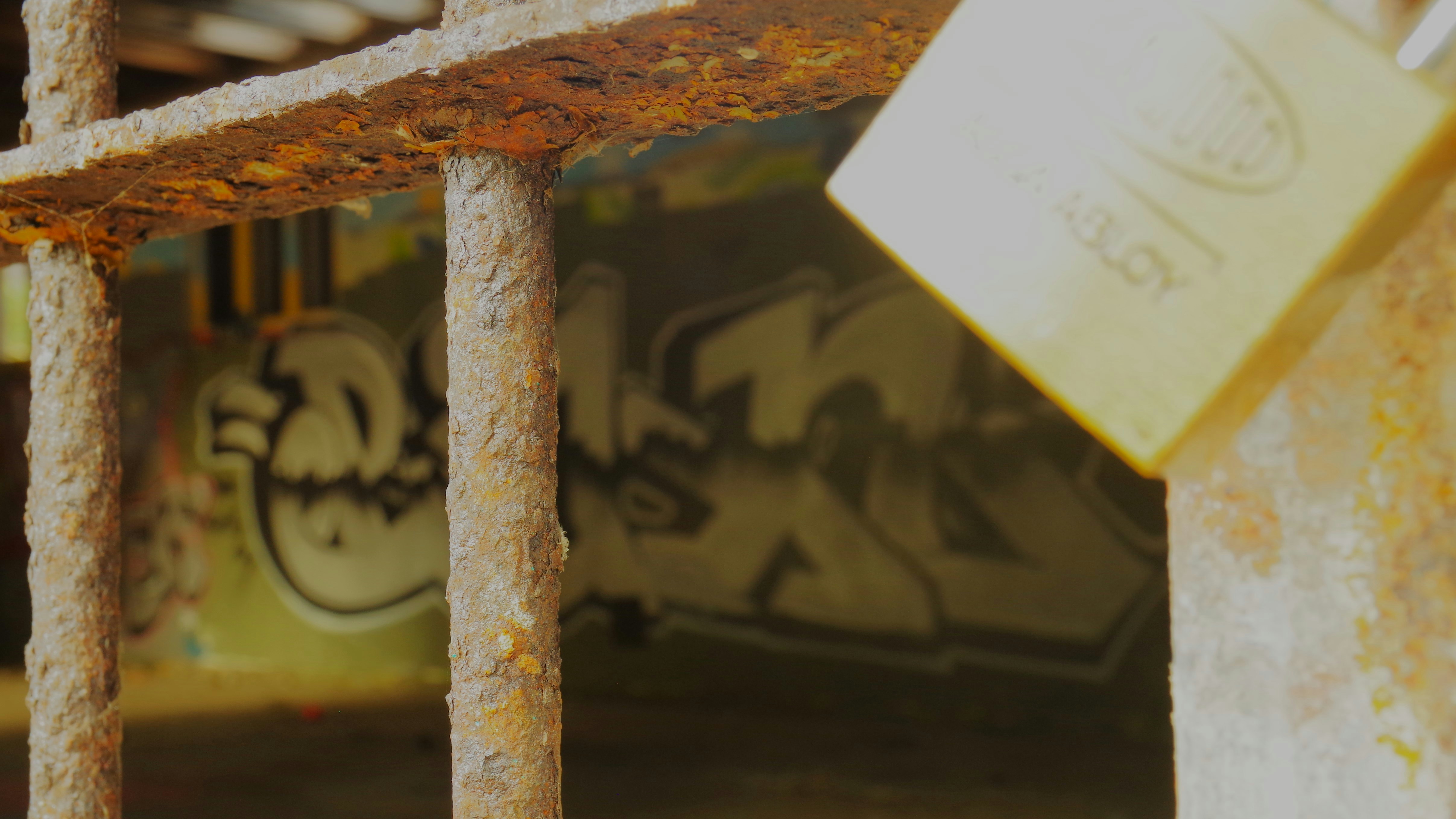 Rusty bars with a padlock and graffiti