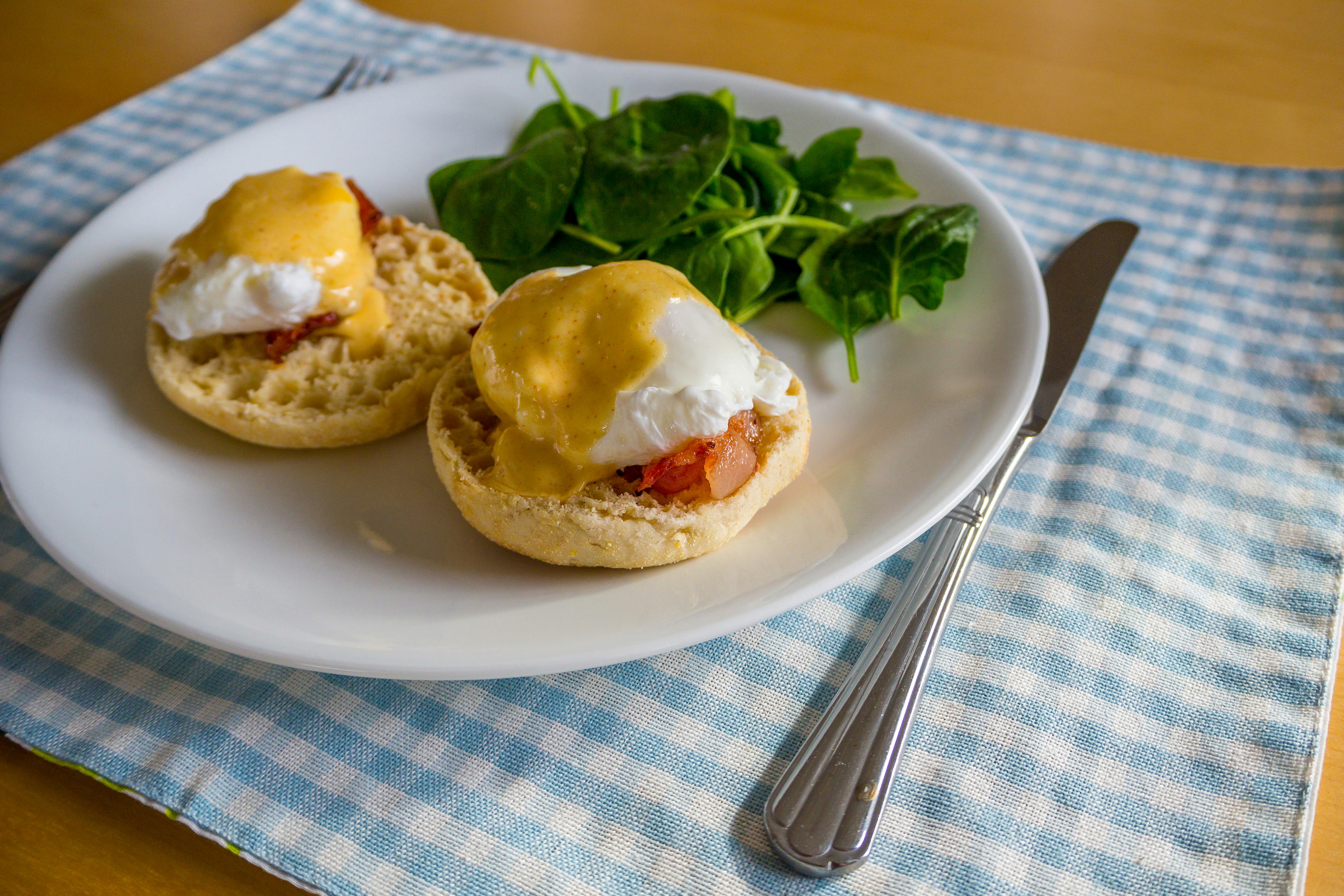 Two eggs benedict with spinach on a plate