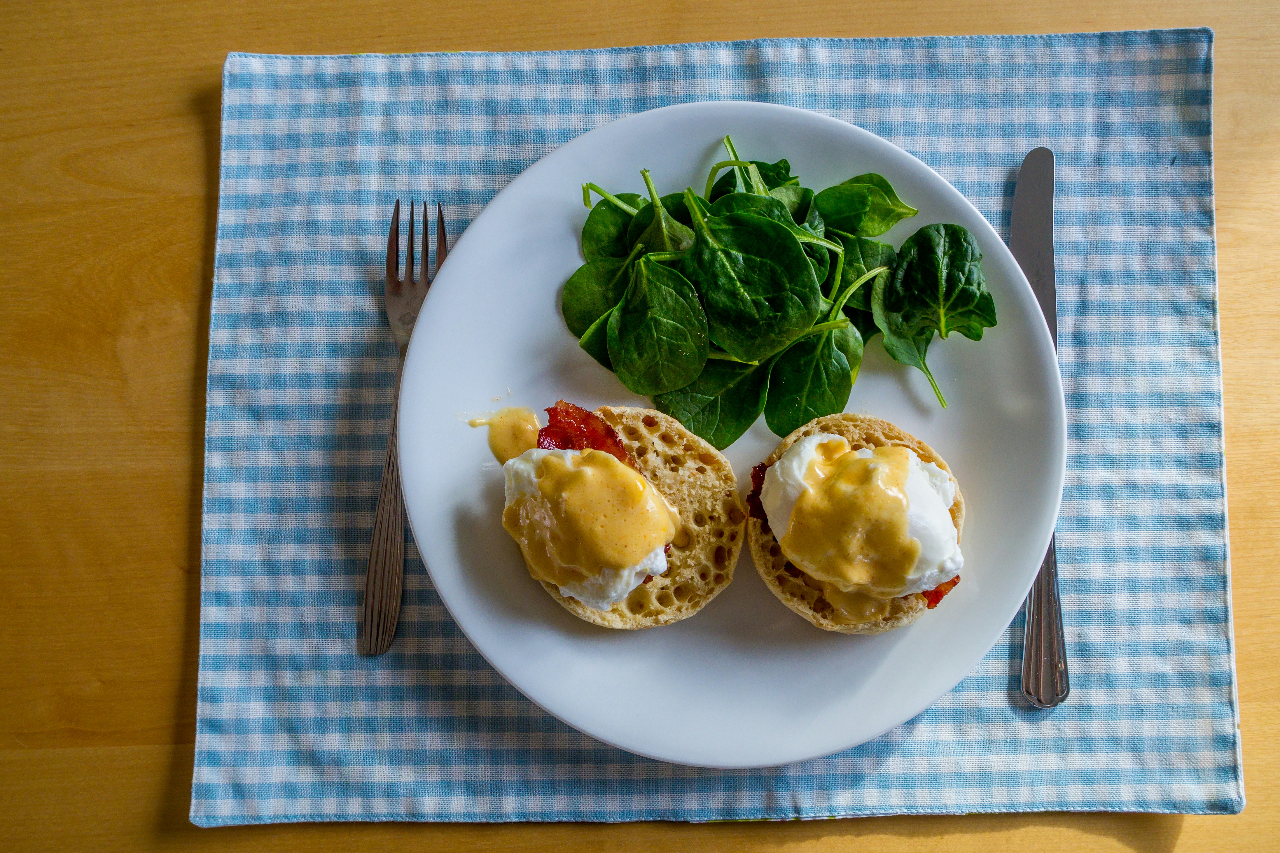 Eggs benedict with a side salad on a plate.