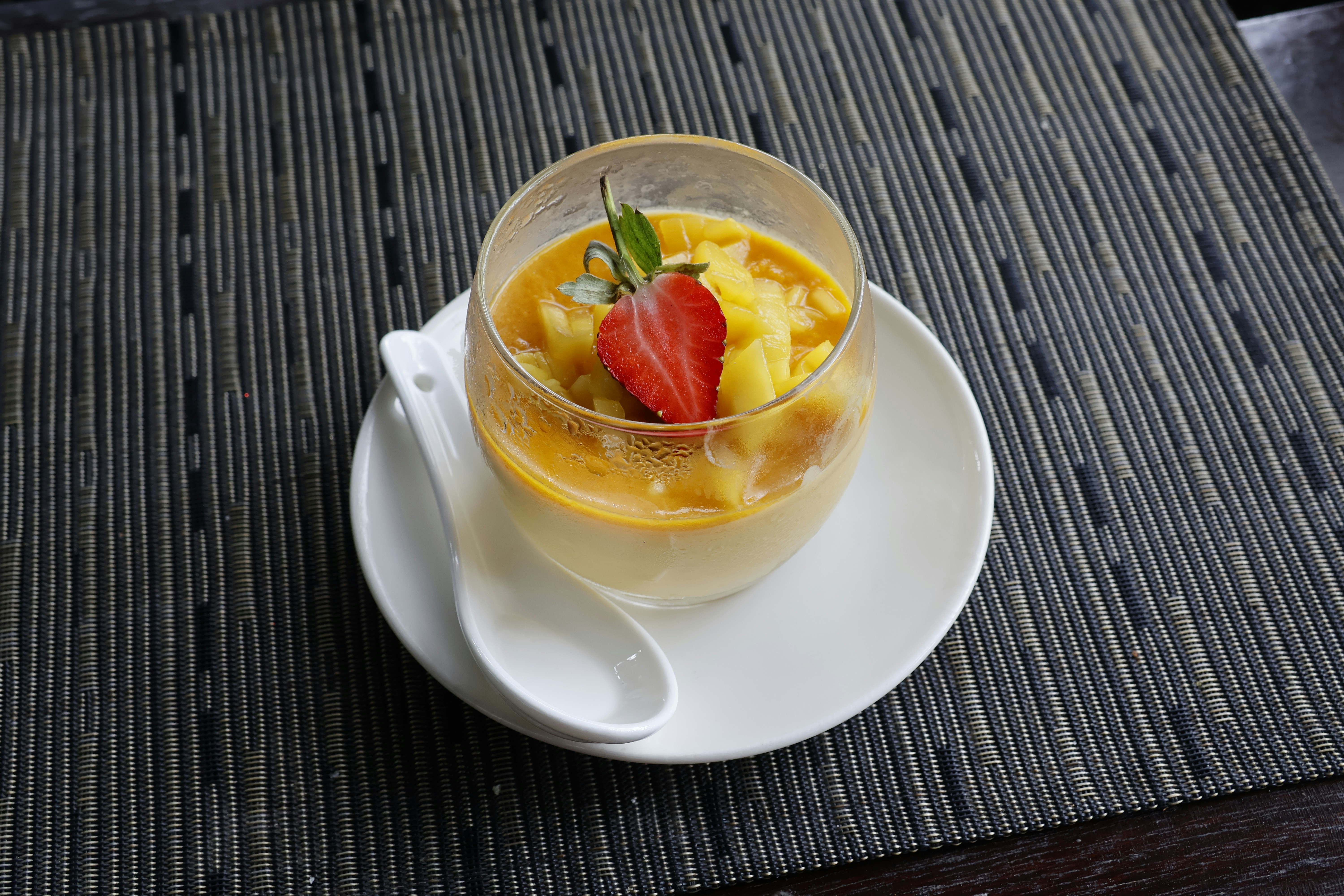A refreshing mango dessert topped with strawberry.