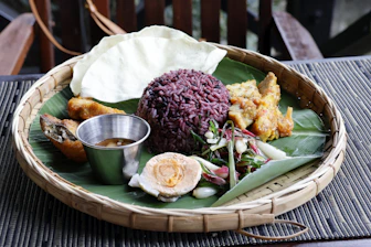 A platter of rice, egg, and other food items.