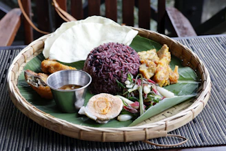A platter of rice, egg, and other food items.