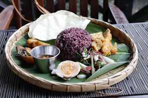 A platter of rice, egg, and other food items.