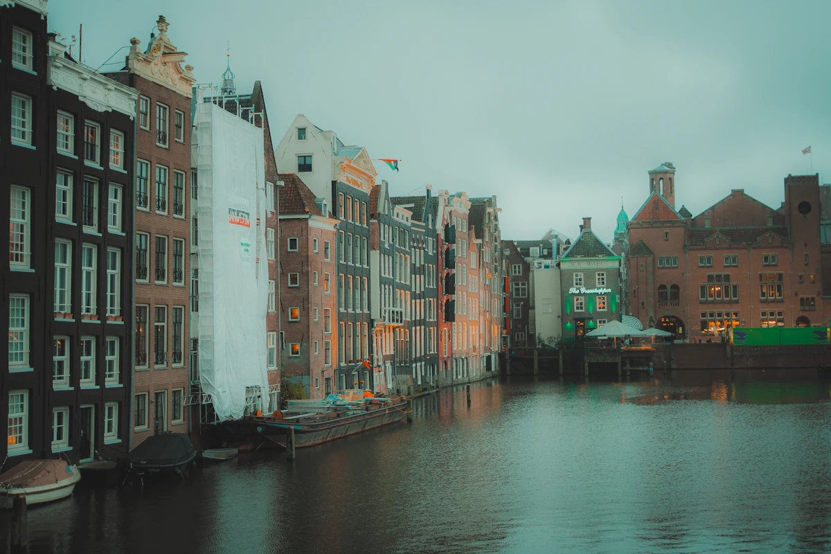 Historic Amsterdam canal houses lining the water in soft evening light