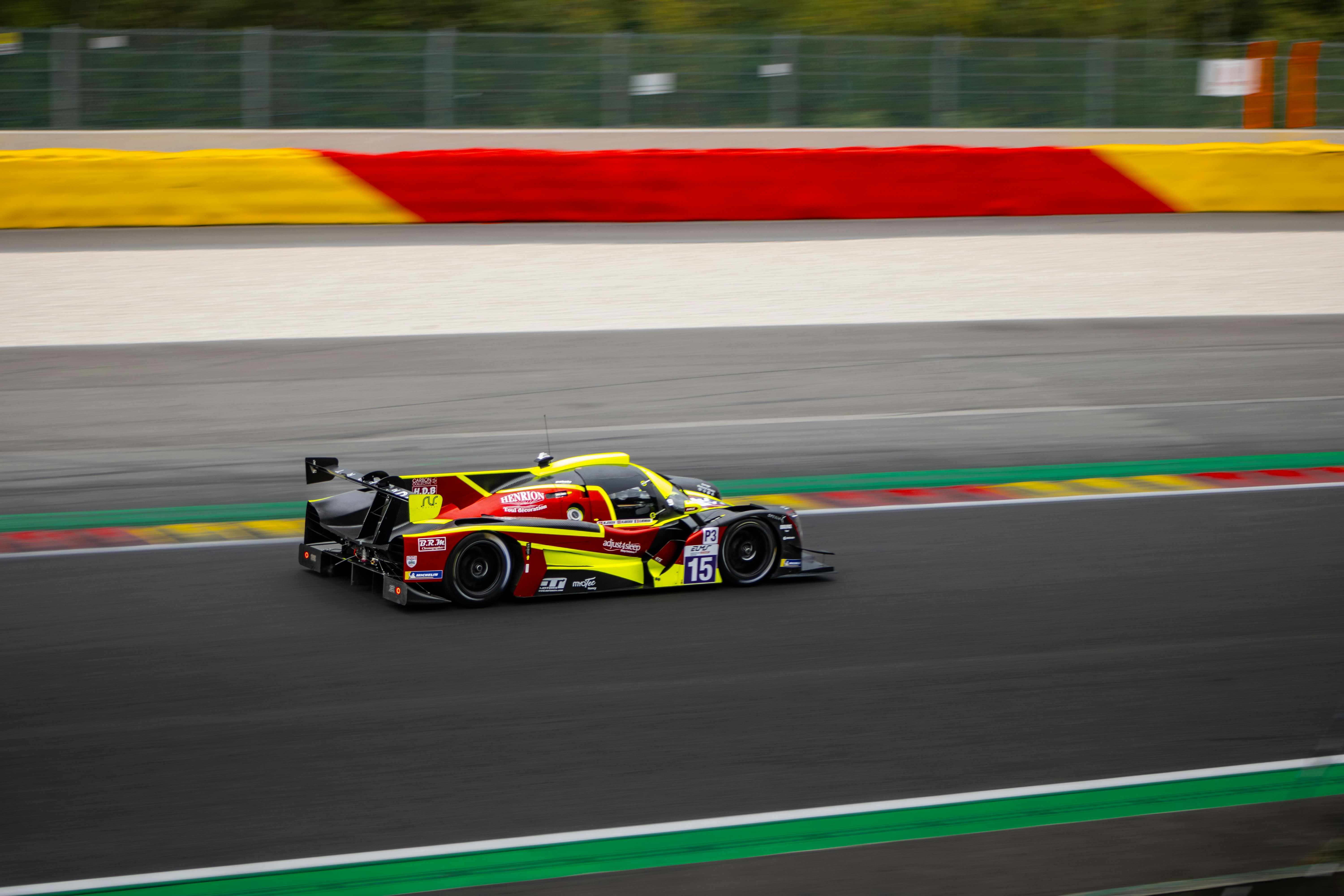 A yellow and red race car speeds down the track.