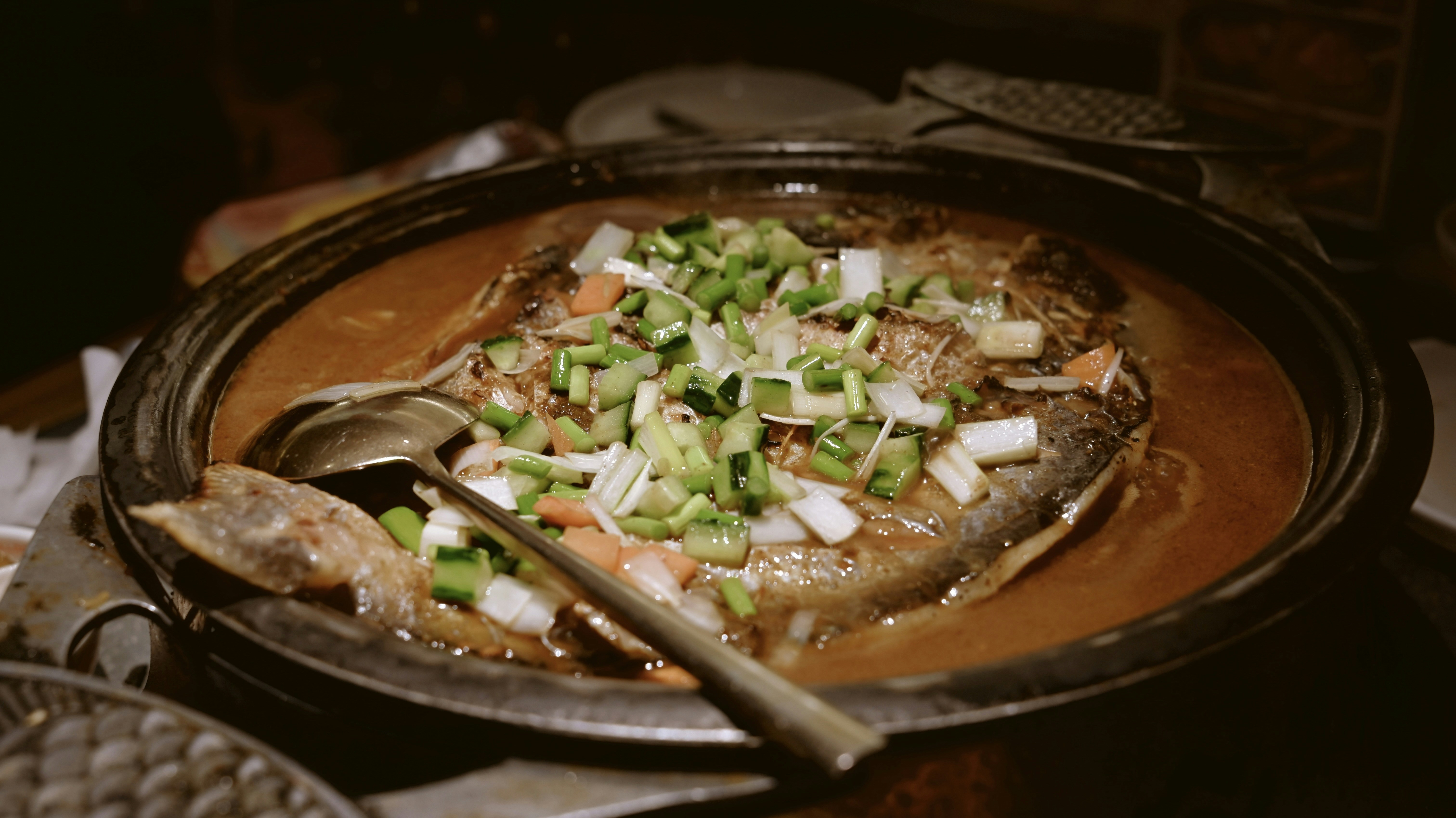 Whole fish dish with chopped green onions and sauce