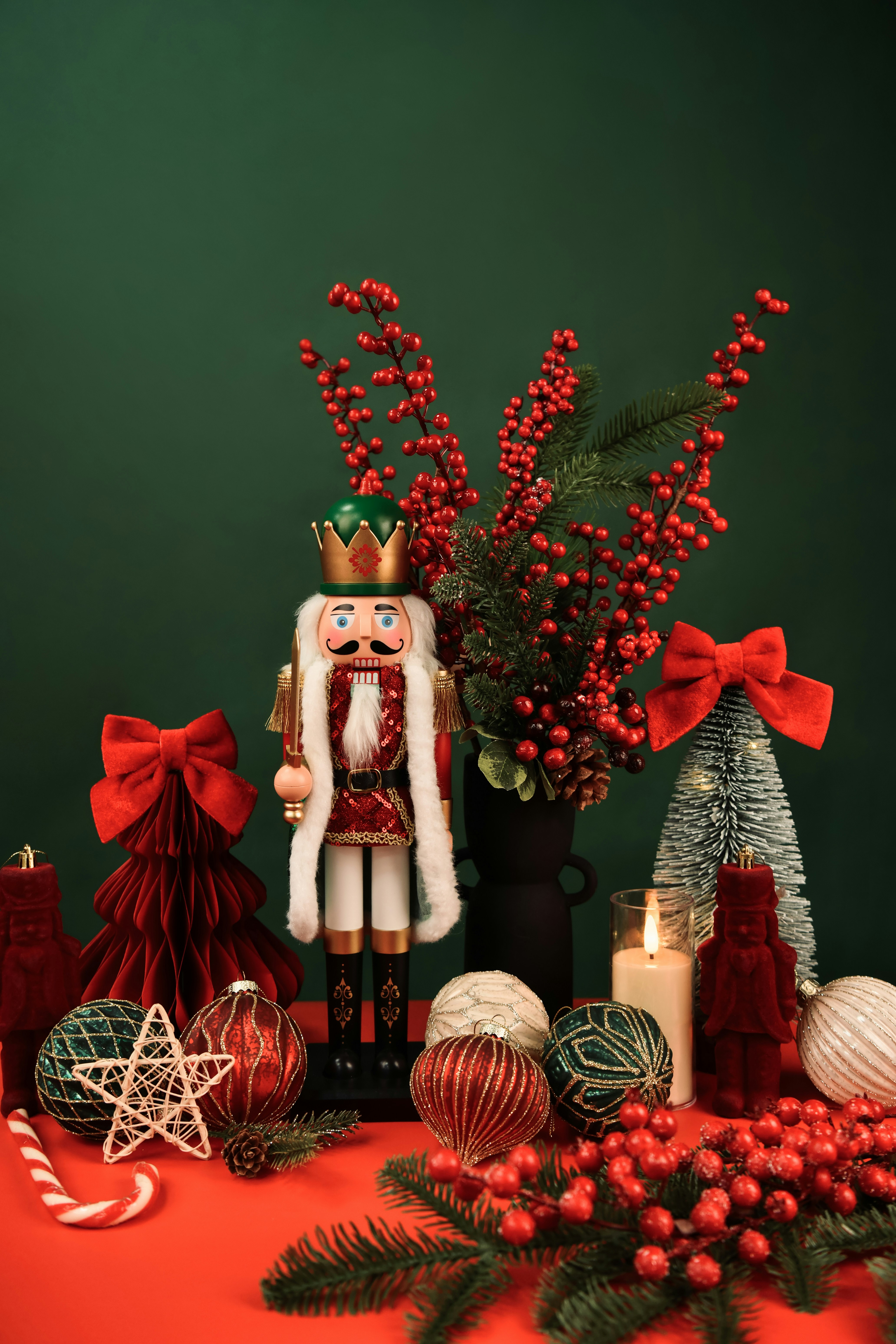 Nutcracker and christmas decorations on red surface