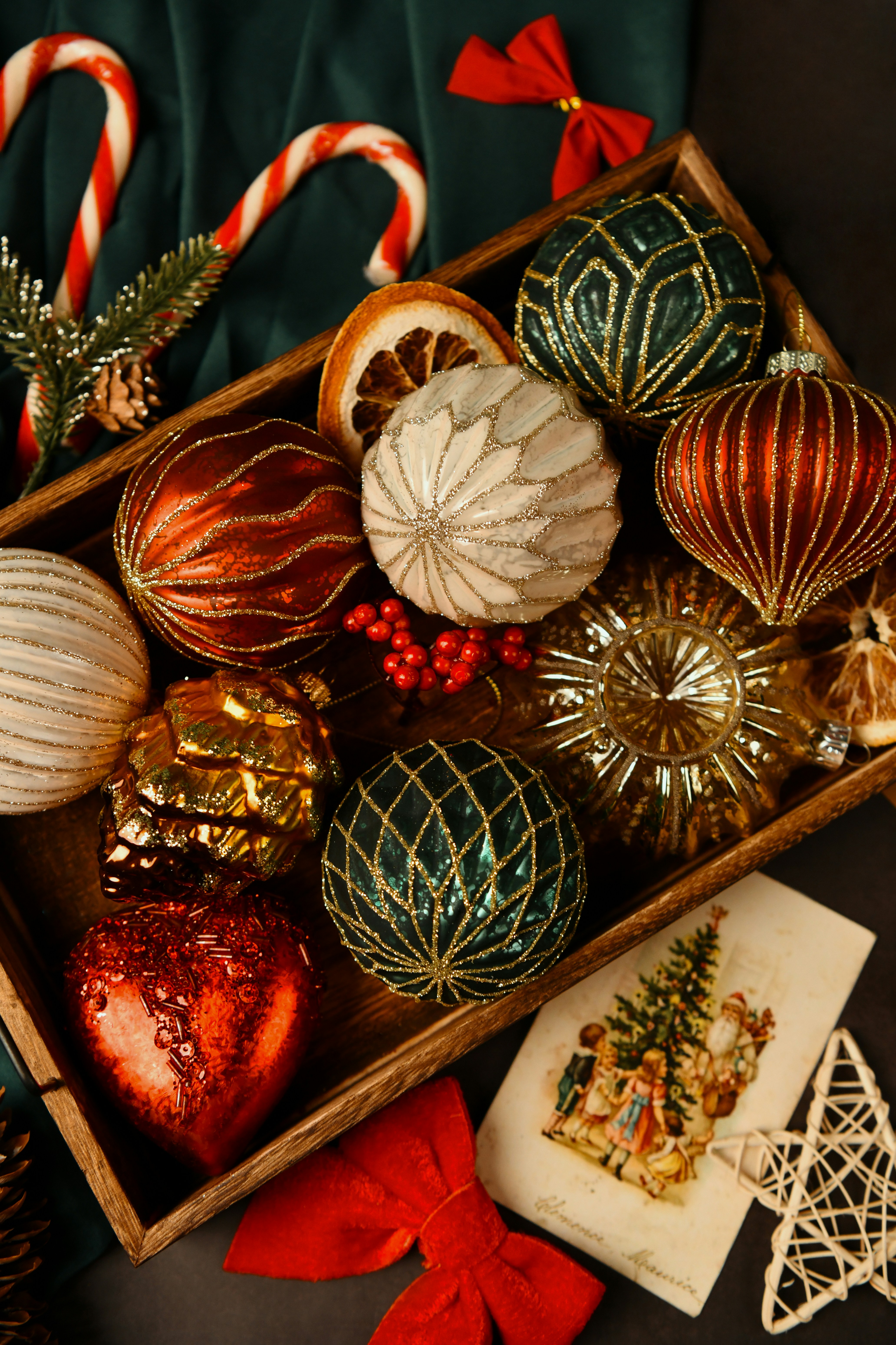Assortment of festive christmas ornaments in a wooden tray.