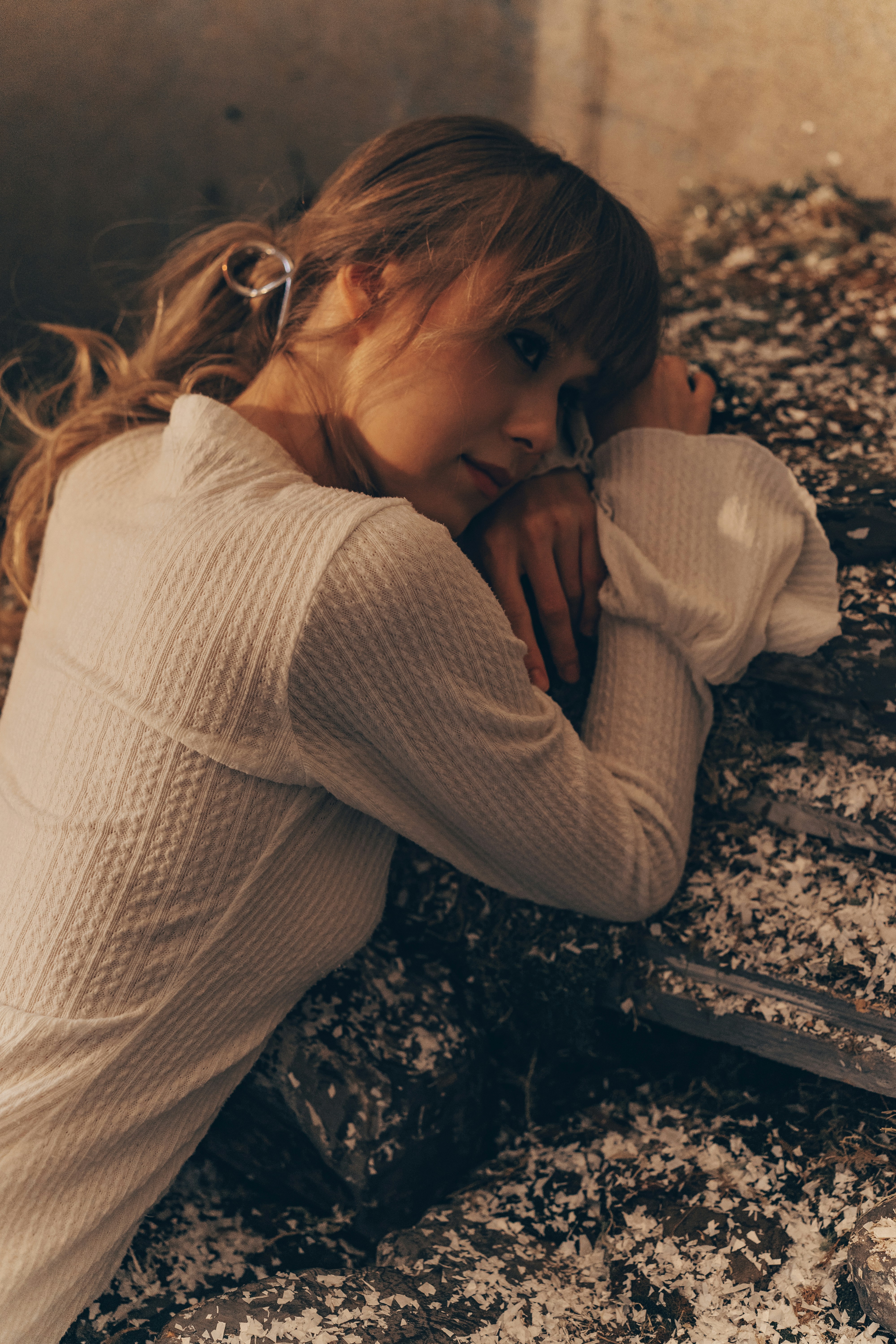 A woman rests her head on her arm.