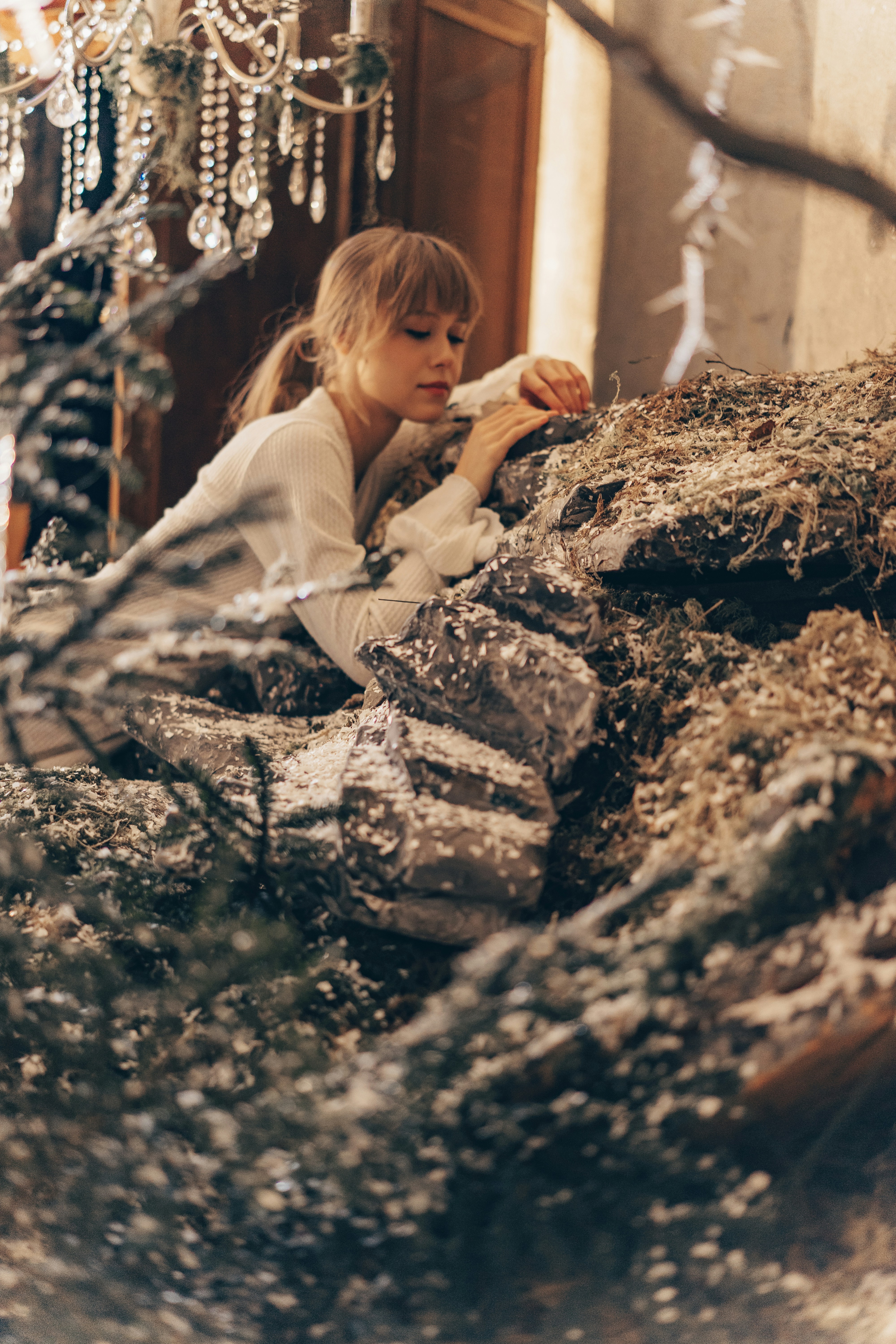 Young woman among snowy rocks and branches