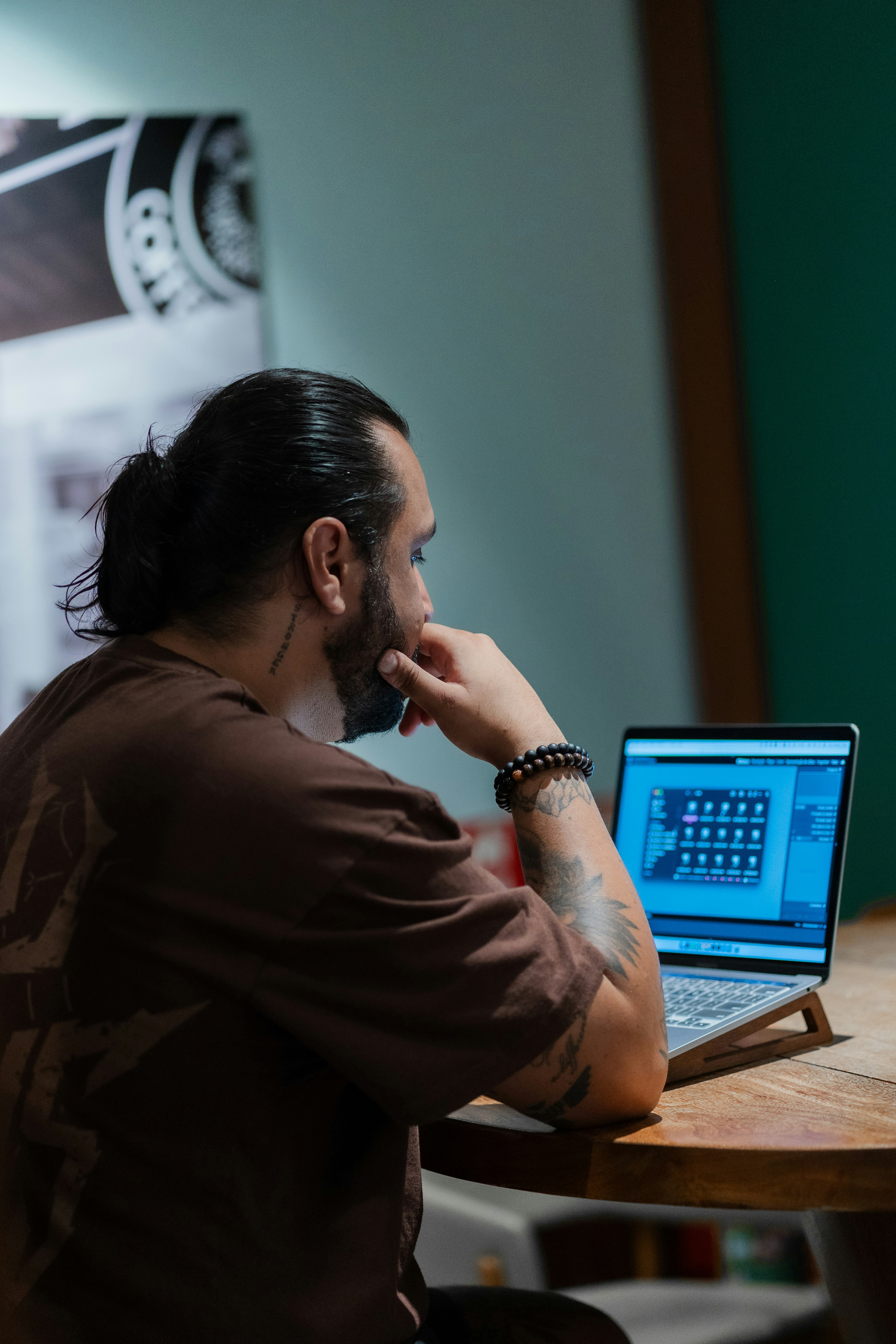 Man with bun hairstyle working on laptop