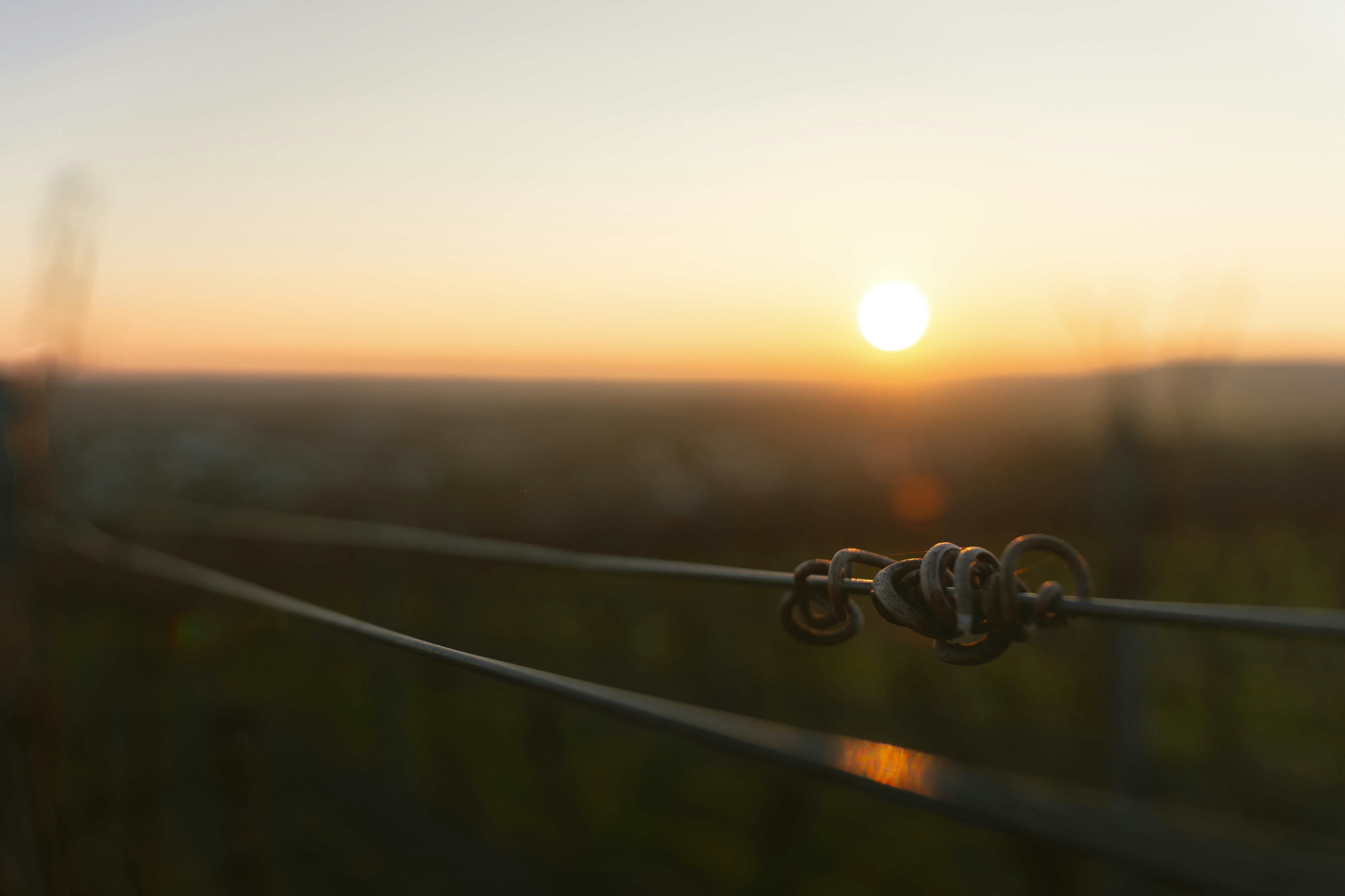 Sunset over a rural landscape with fence wire fence