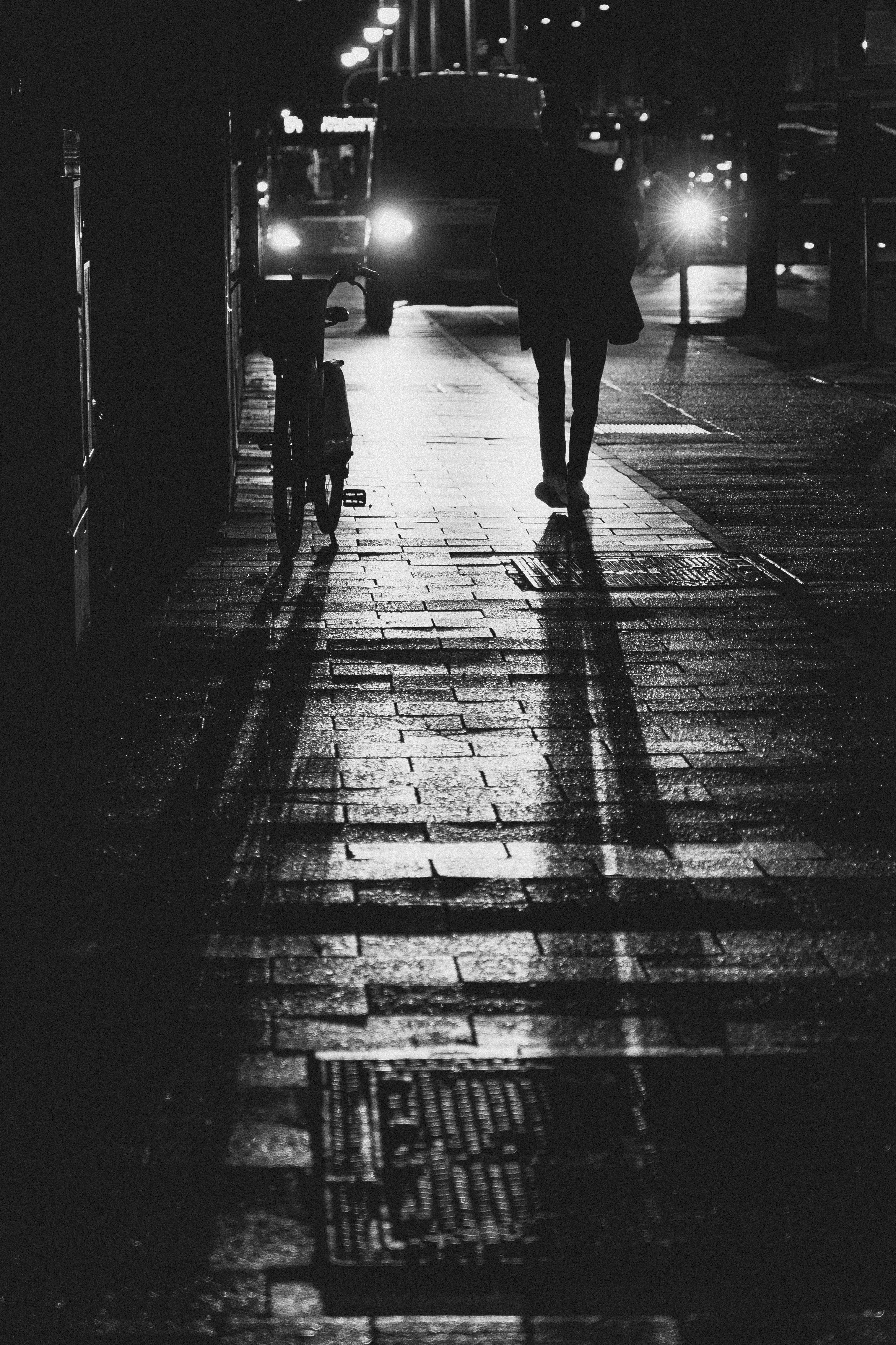 Person walking on wet city street at night