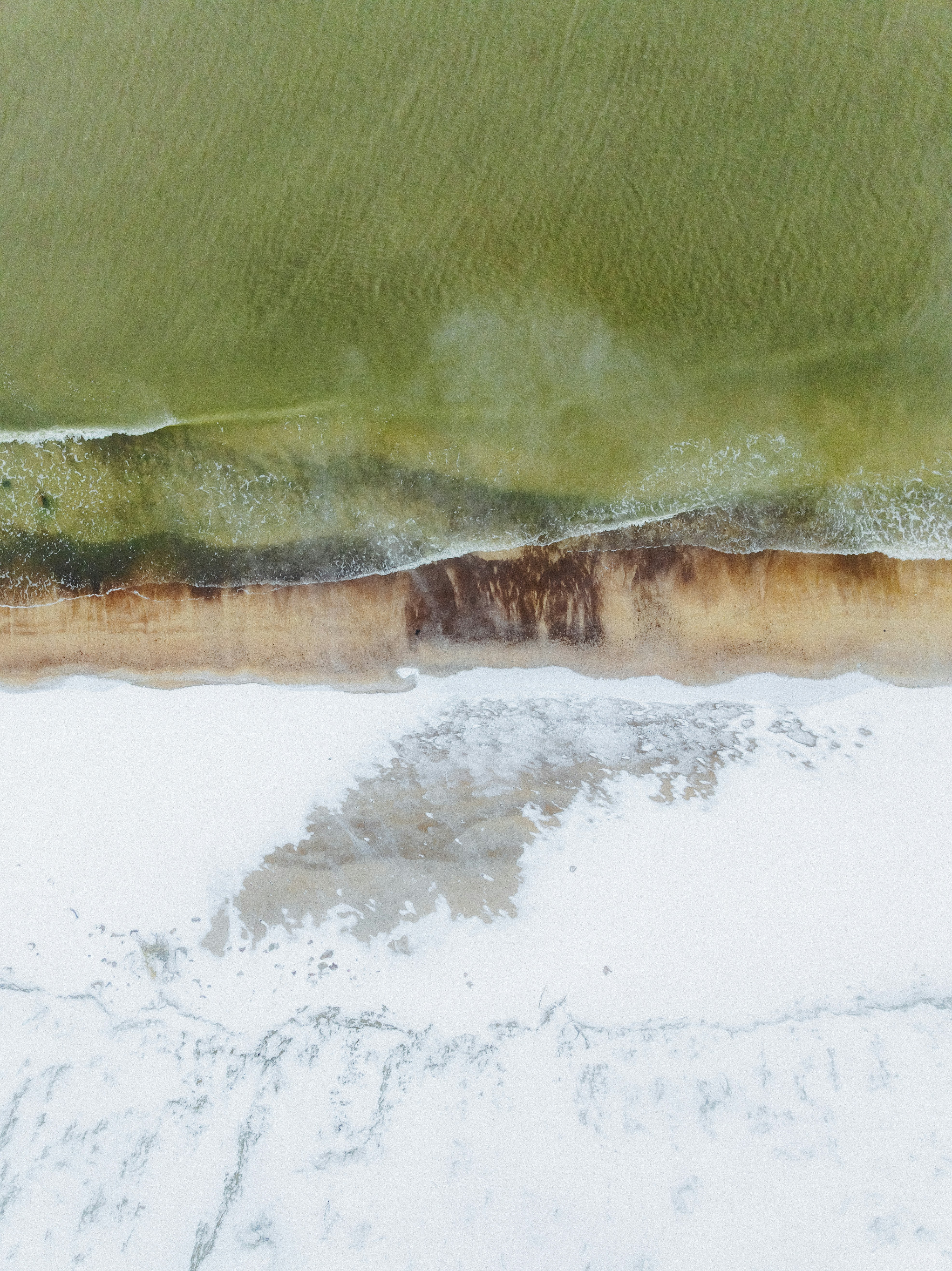 Aerial view of a sandy beach with ocean waves