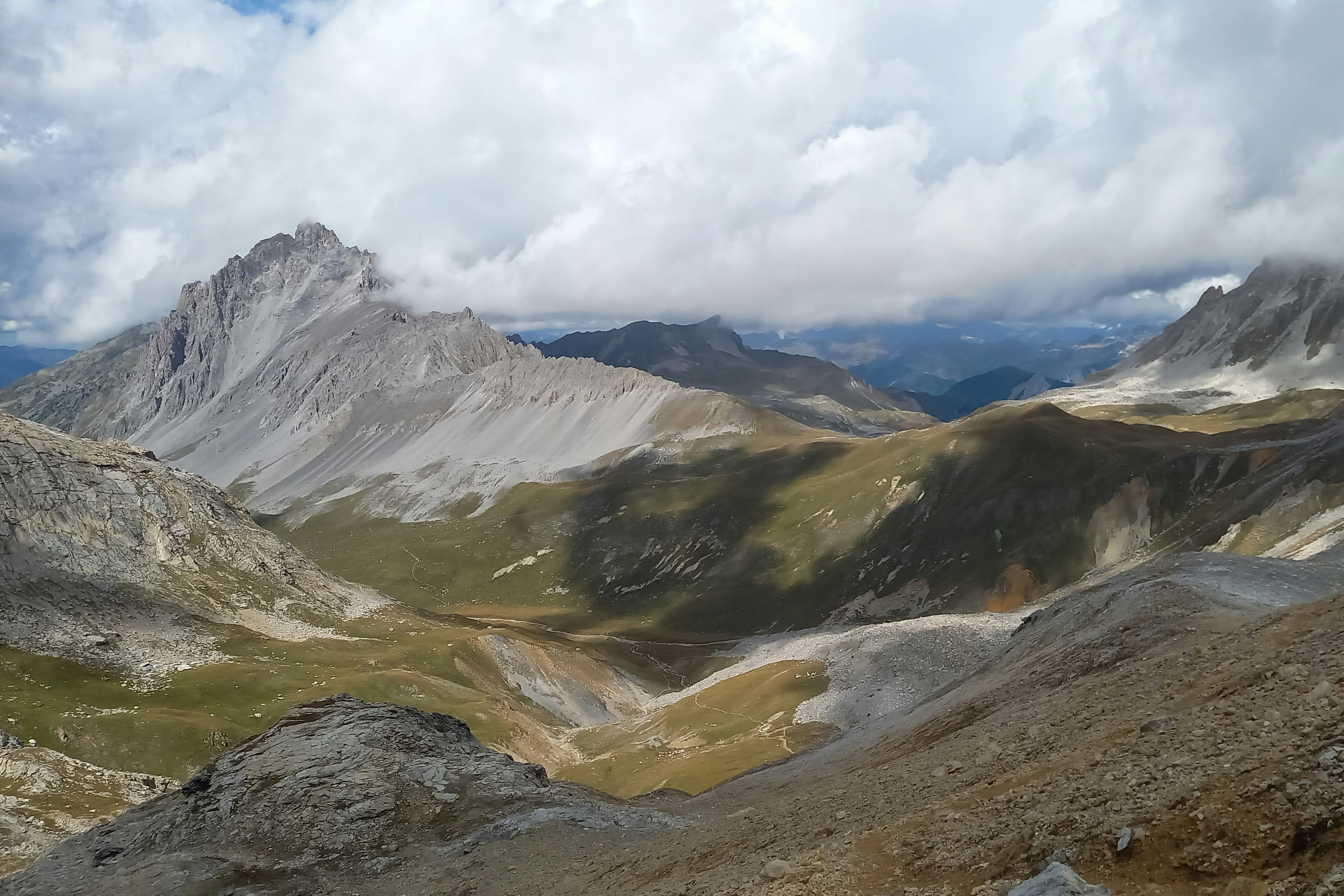 Rocky mountain landscape with clouds and green patches