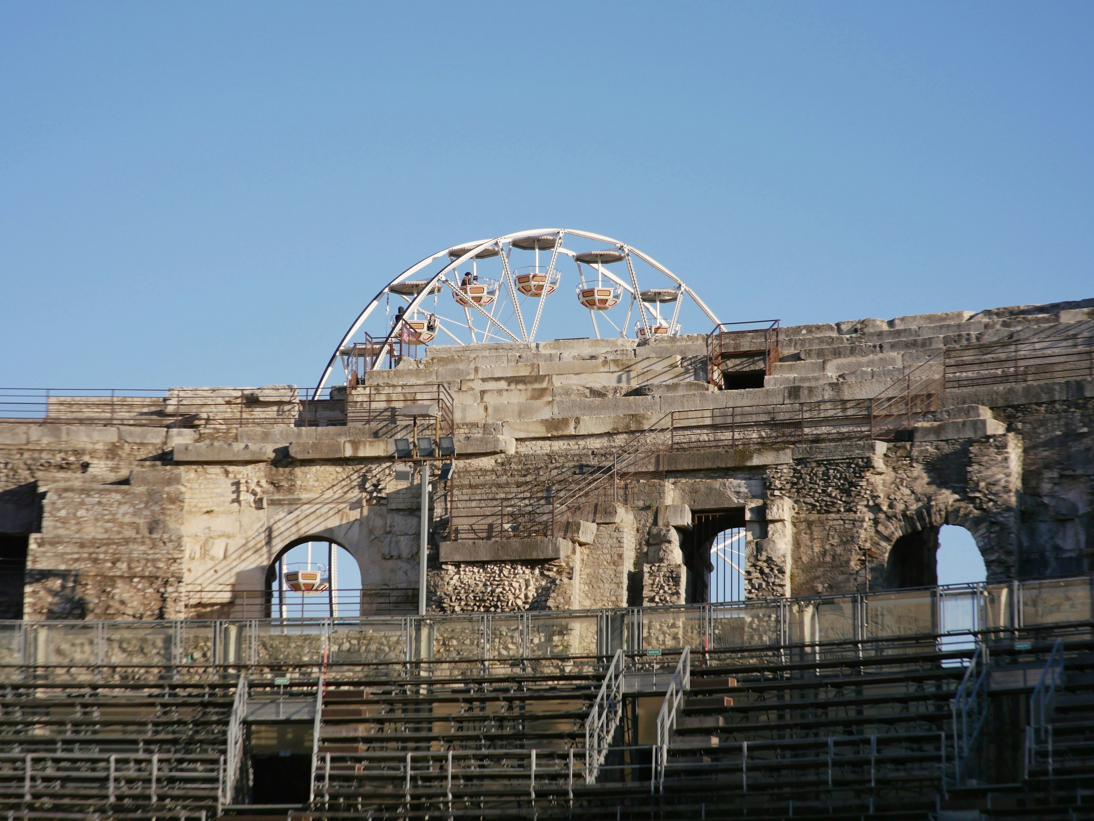Ferris wheel behind ancient stone ruins