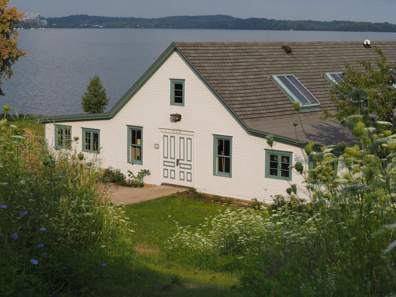 White house with green trim beside the water